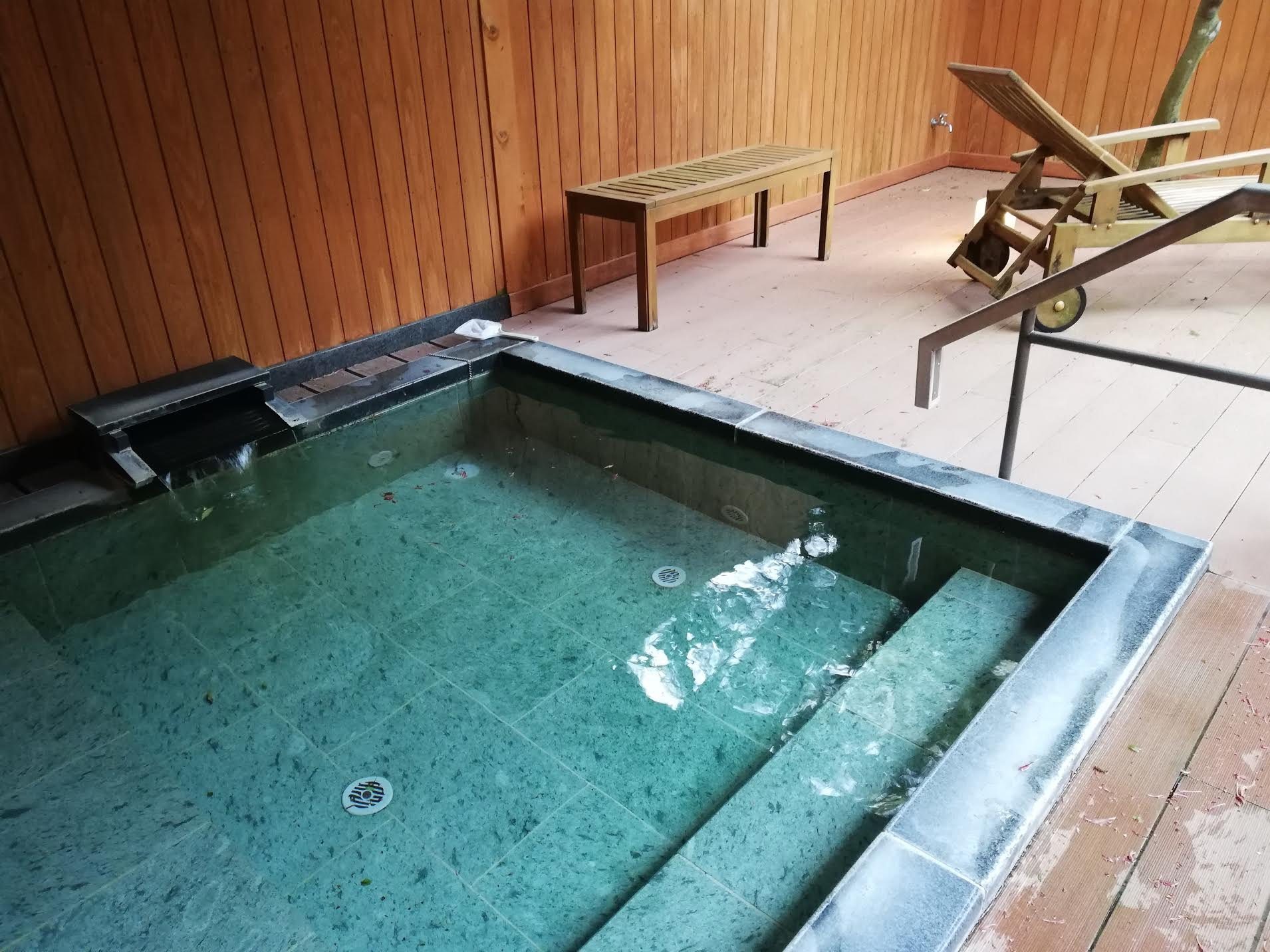 A clear-water bath on its wooden deck.