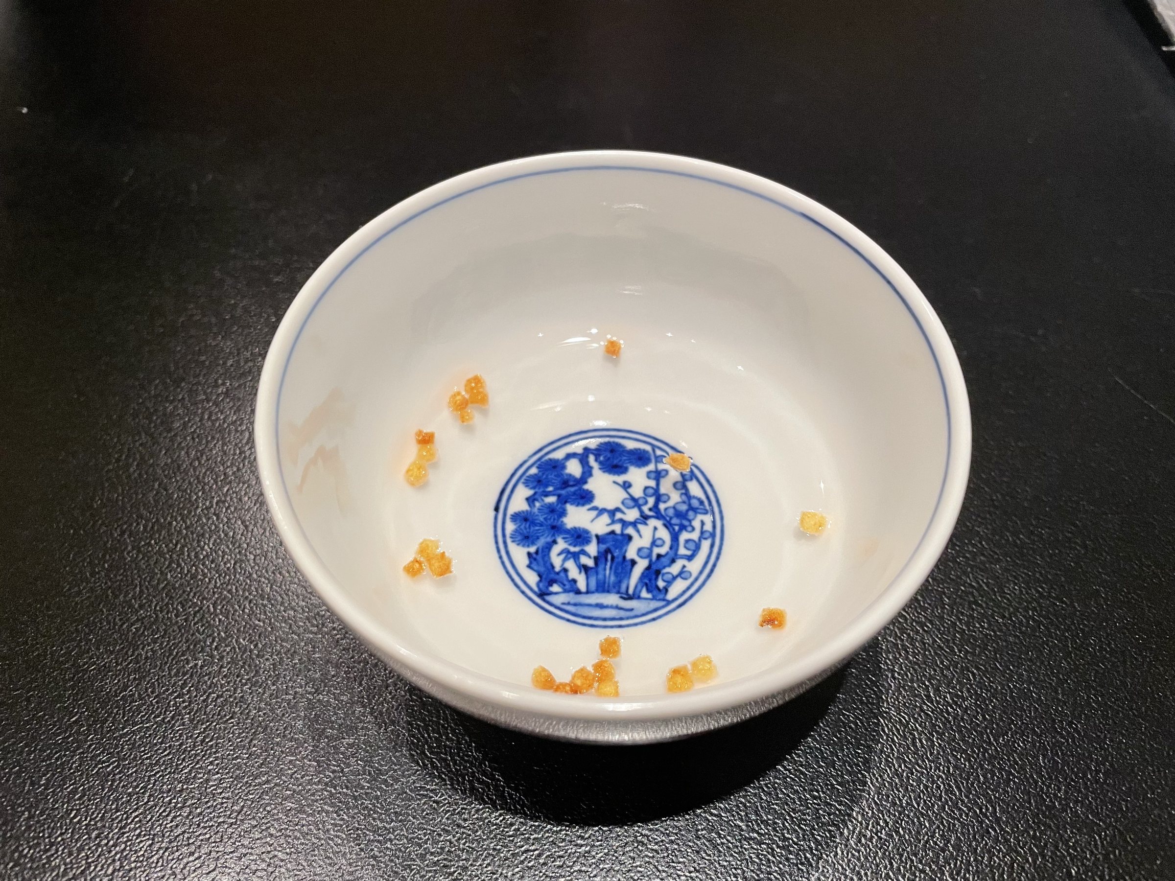 The welcome bowl of lightly salted hot water, emptied down to its last toasted grains.