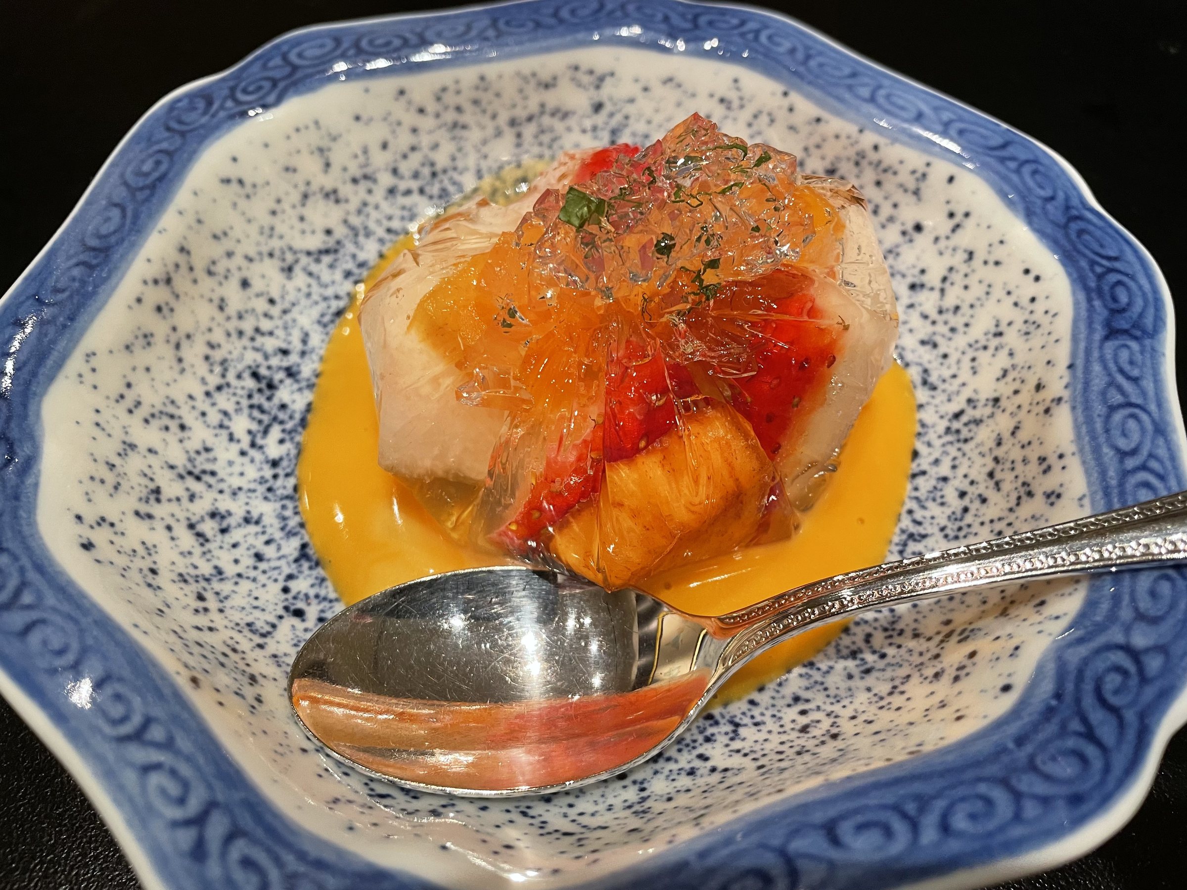 Seasonal fruit in jelly, over a custard-like sauce.