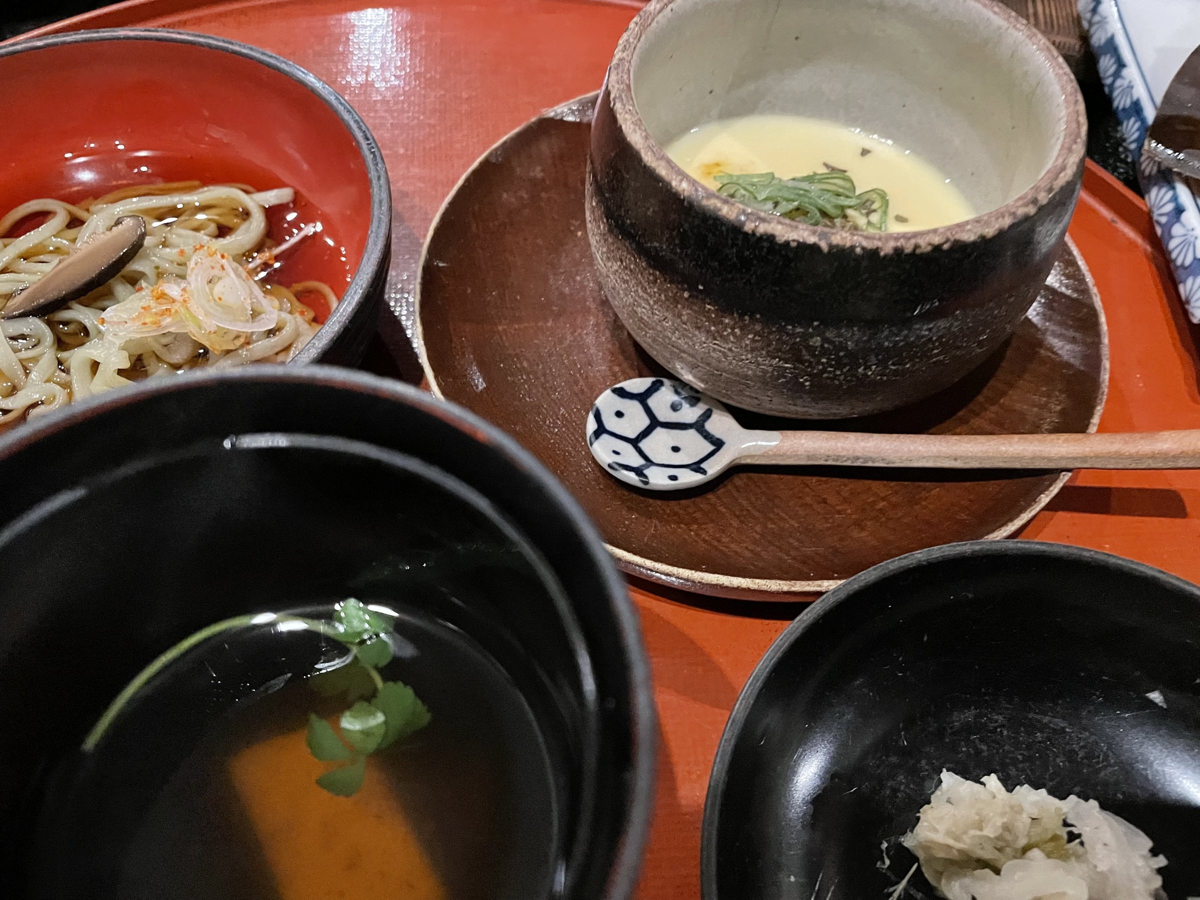 The chawanmushi in an earthenware cup, beside the udon and soup.
