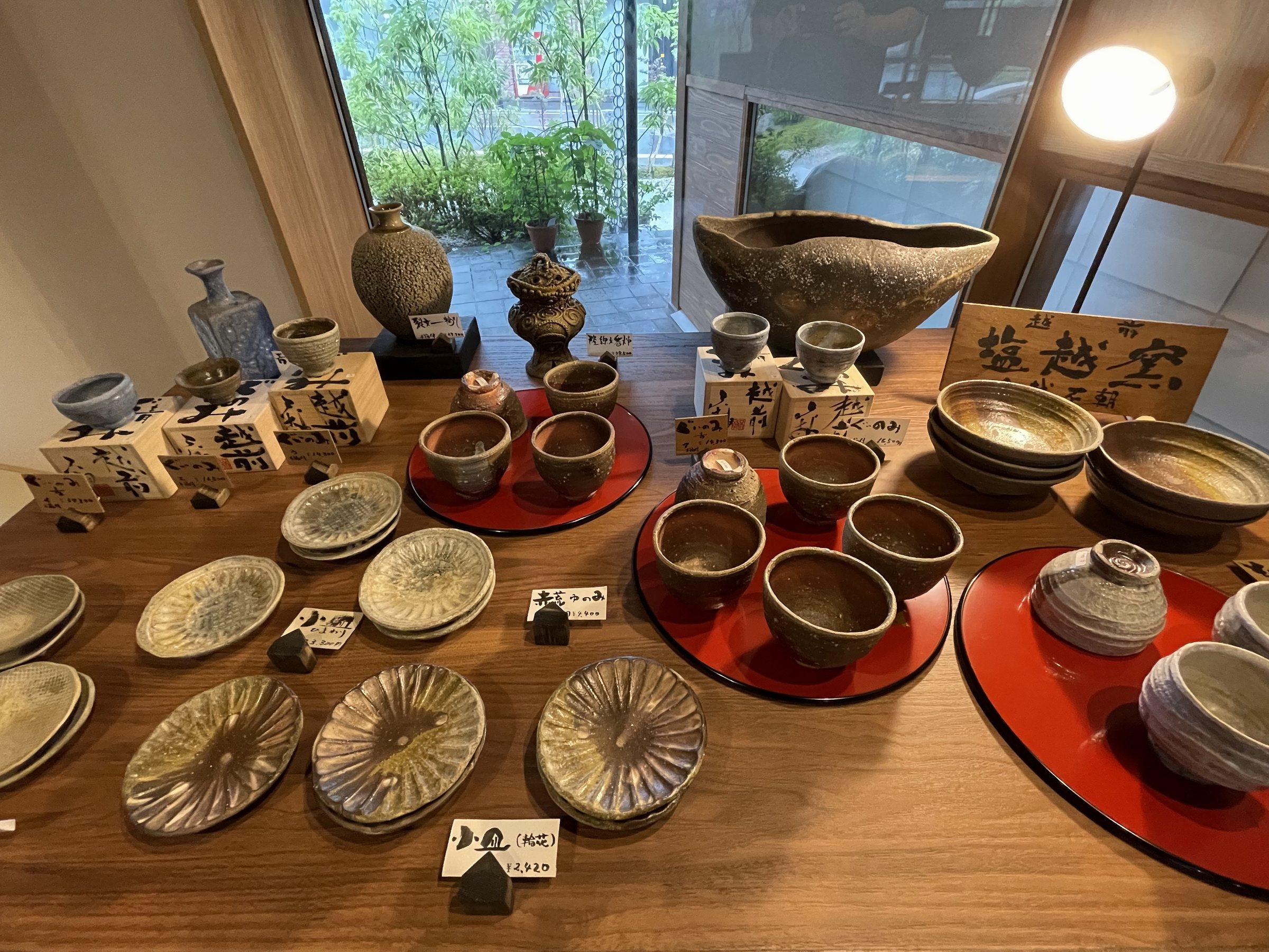 Bowls, cups and plates laid out for sale in the shop.