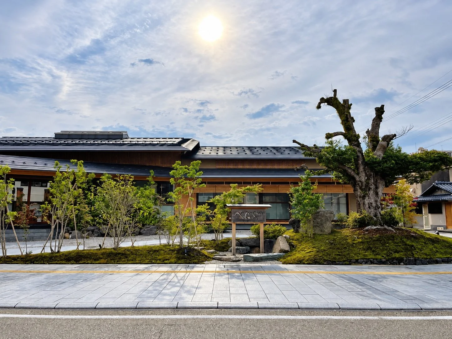 The low, newly built ryokan and its garden in the morning light.