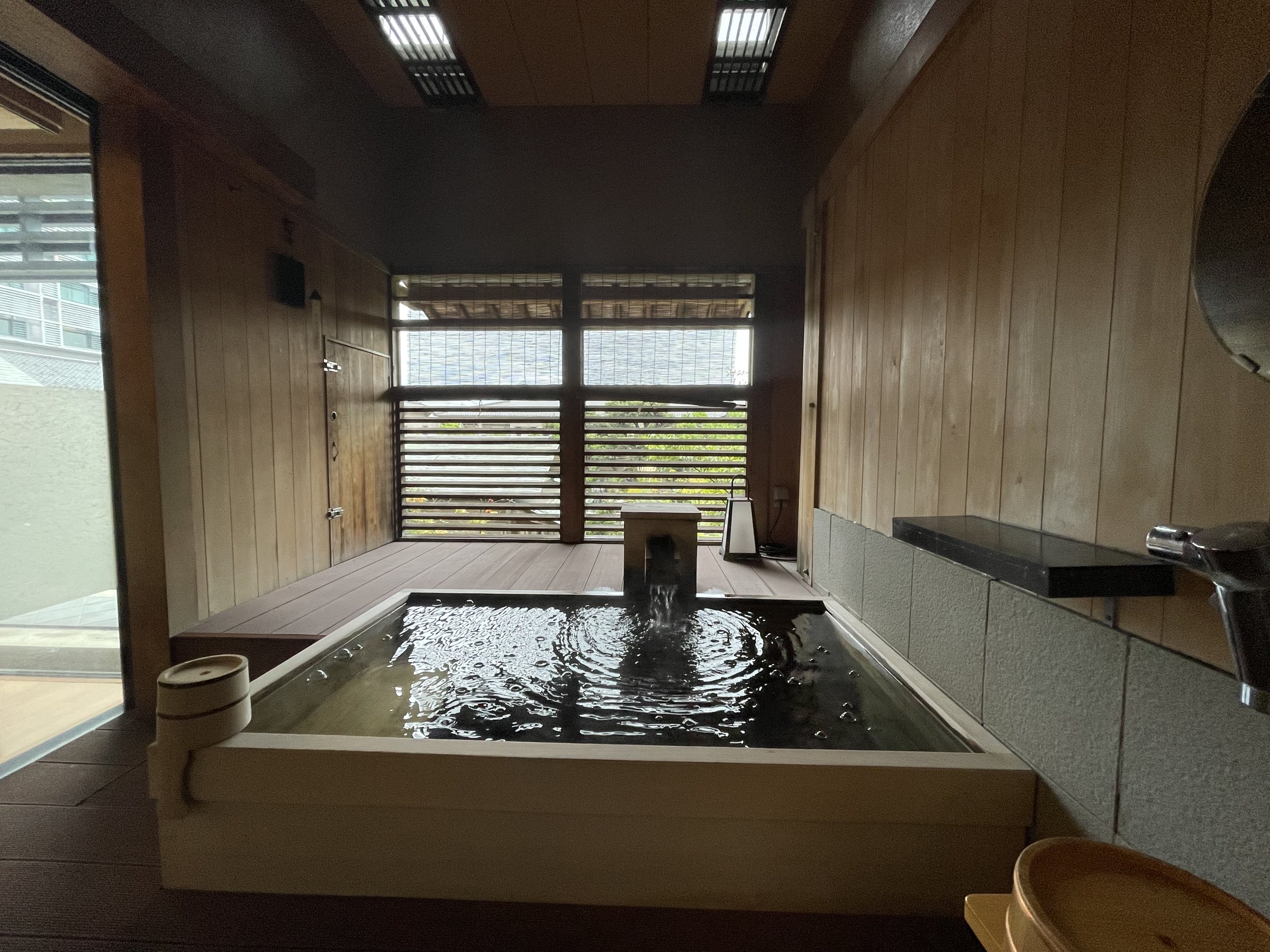 The room’s private bath, filled to the brim, with hot water pouring in.