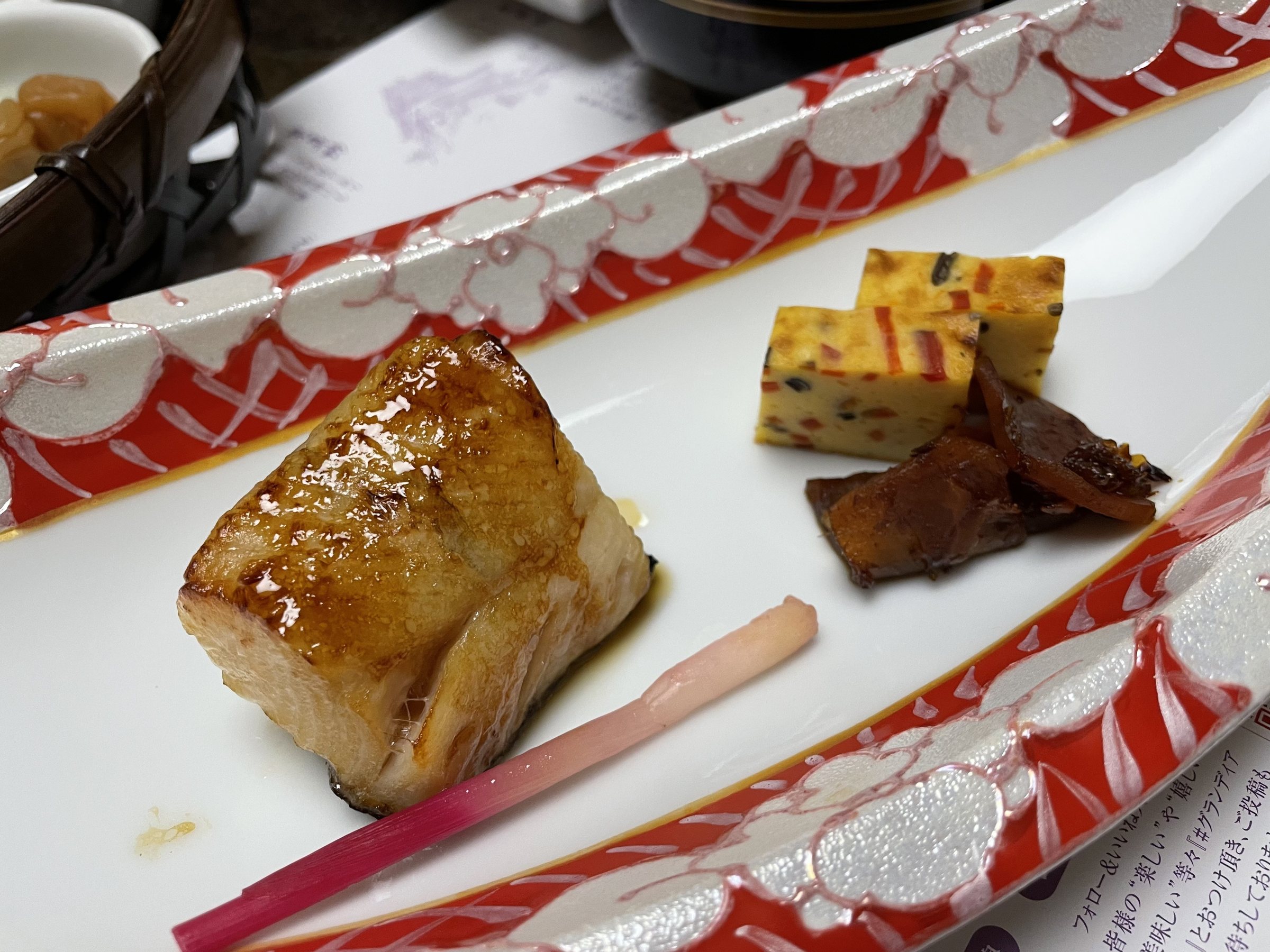 Grilled fish with rolled omelet on a long dish.
