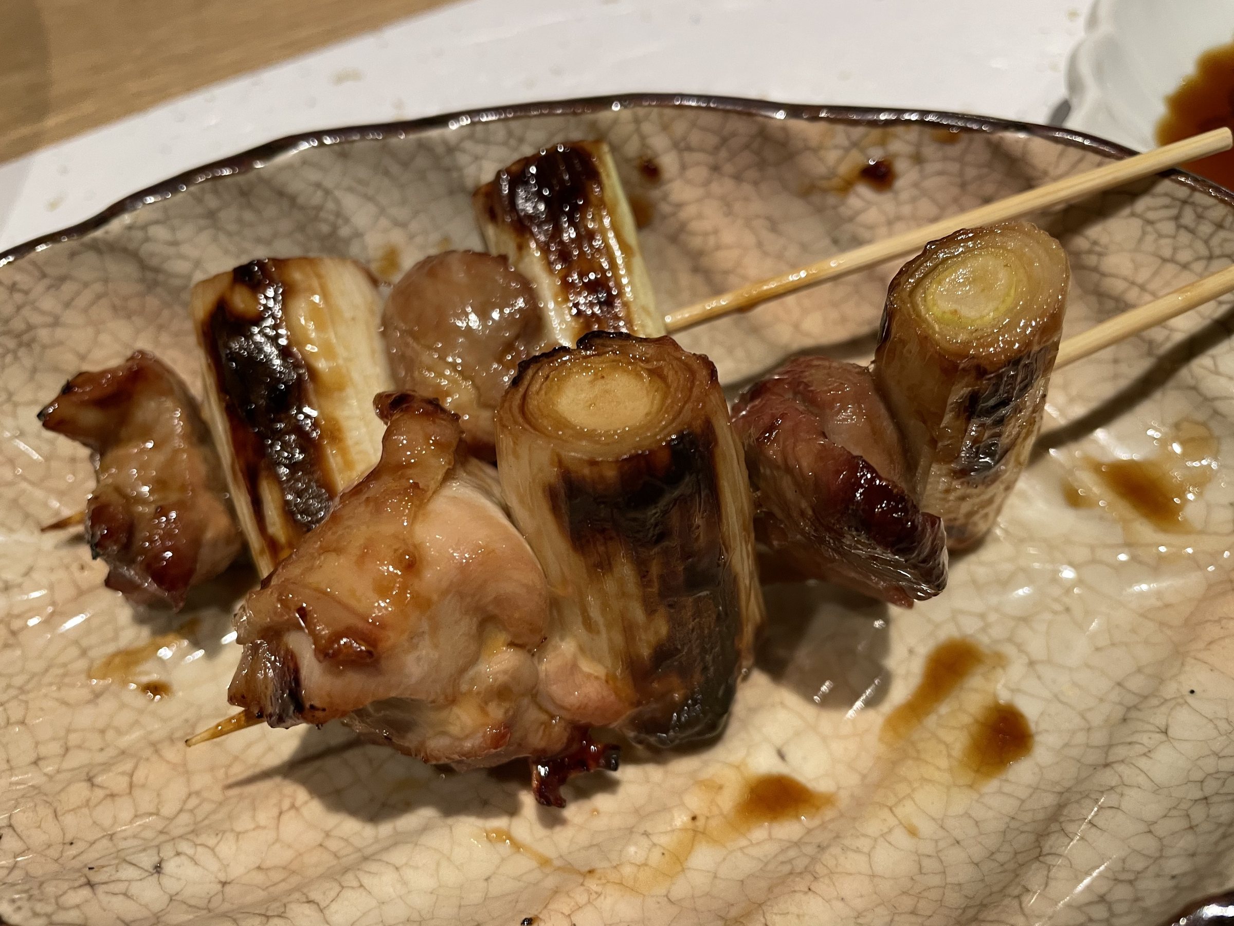Skewers of grilled chicken and charred leek.