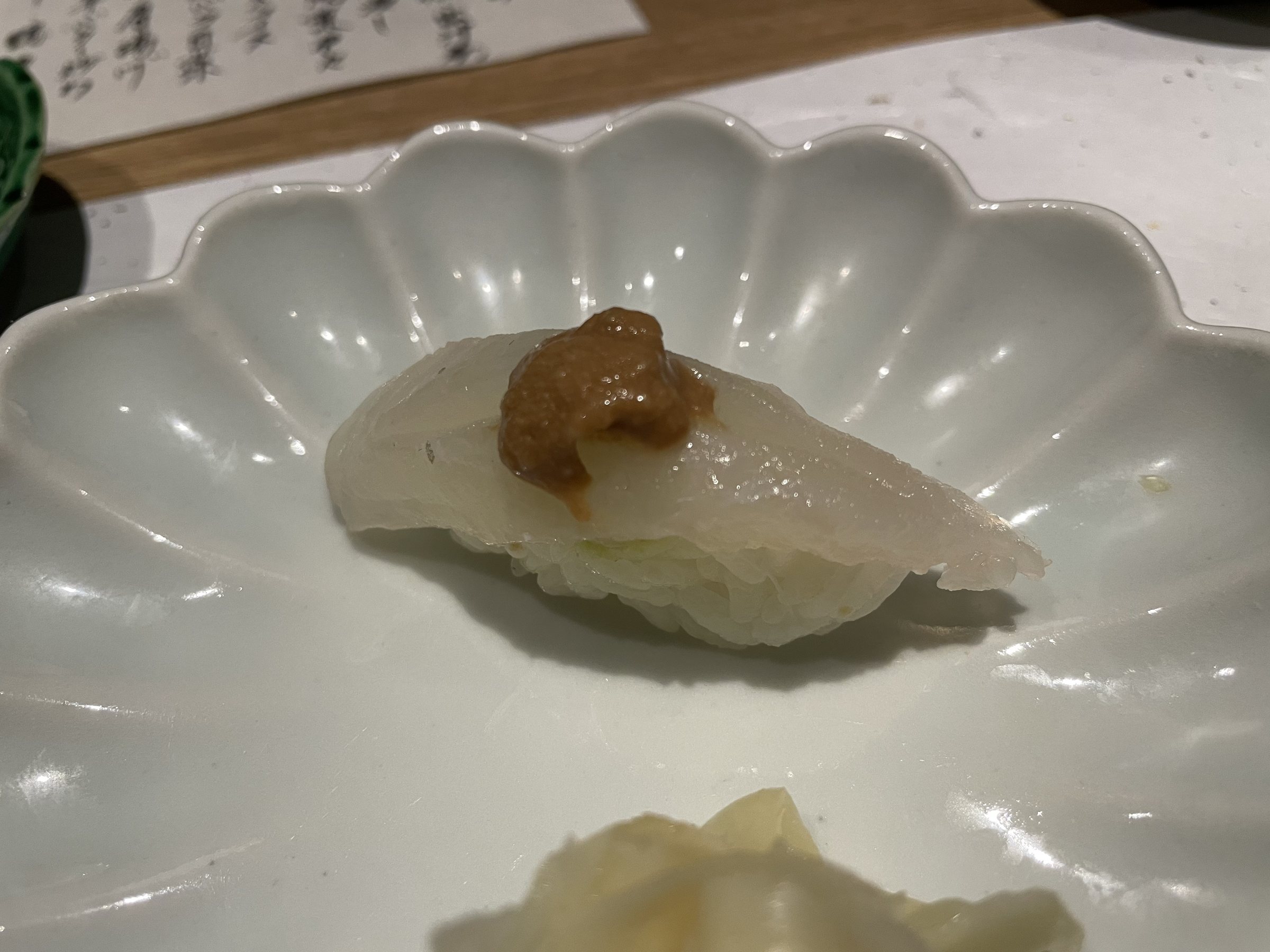 White-fish nigiri topped with a dab of brown paste.