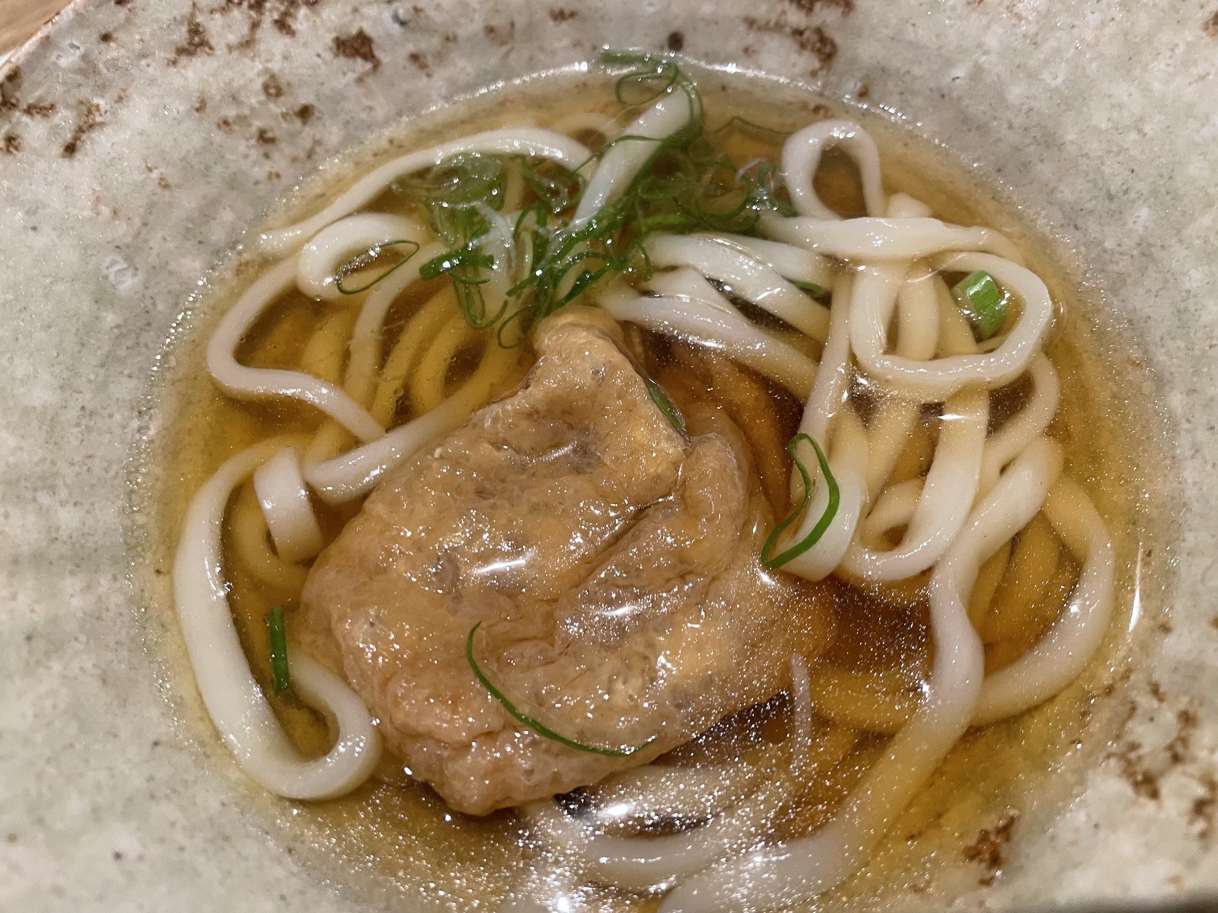 Another small bowl of udon, topped with simmered fried tofu and spring onion.