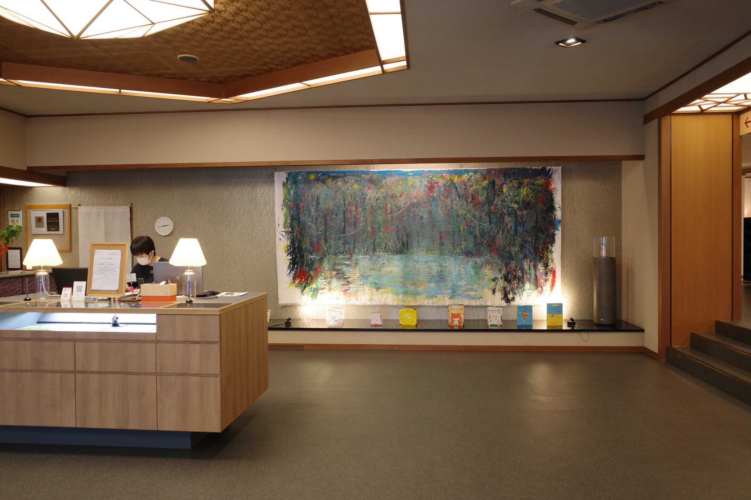 The reception desk, with a large painting behind it.