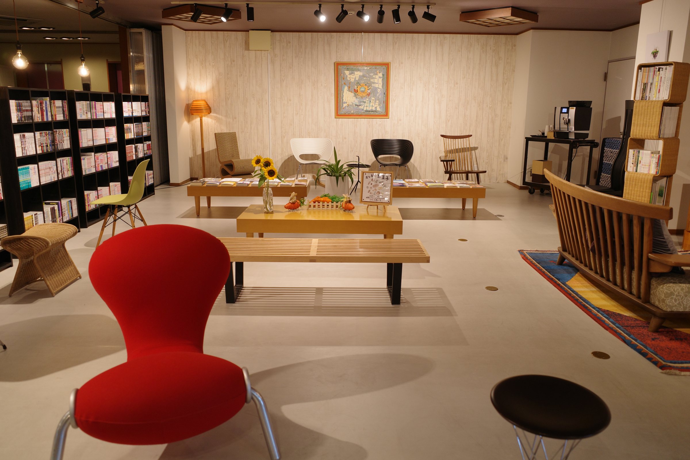 The library corner of the lobby, with bookshelves and designer chairs.