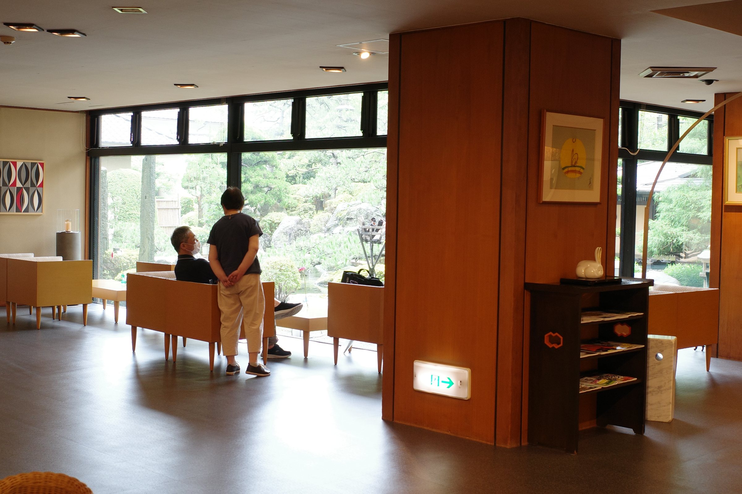 Armchairs by the lobby’s tall windows onto the garden.