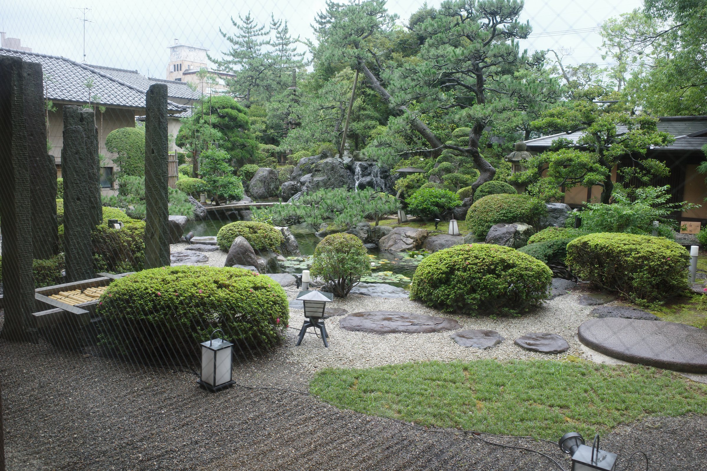 Pines and a lantern on the garden’s raked gravel.