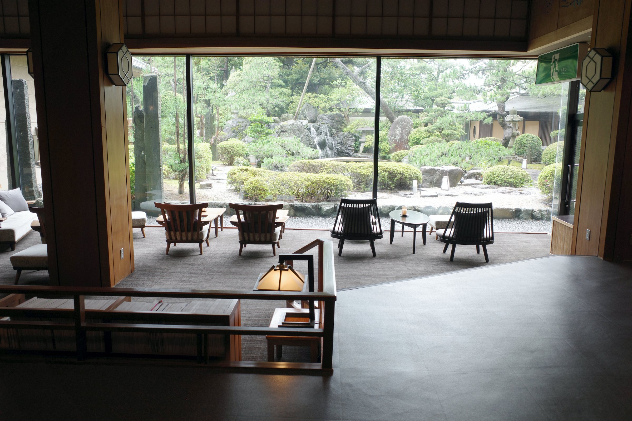 A lounge with low chairs facing a full-height window onto the garden.