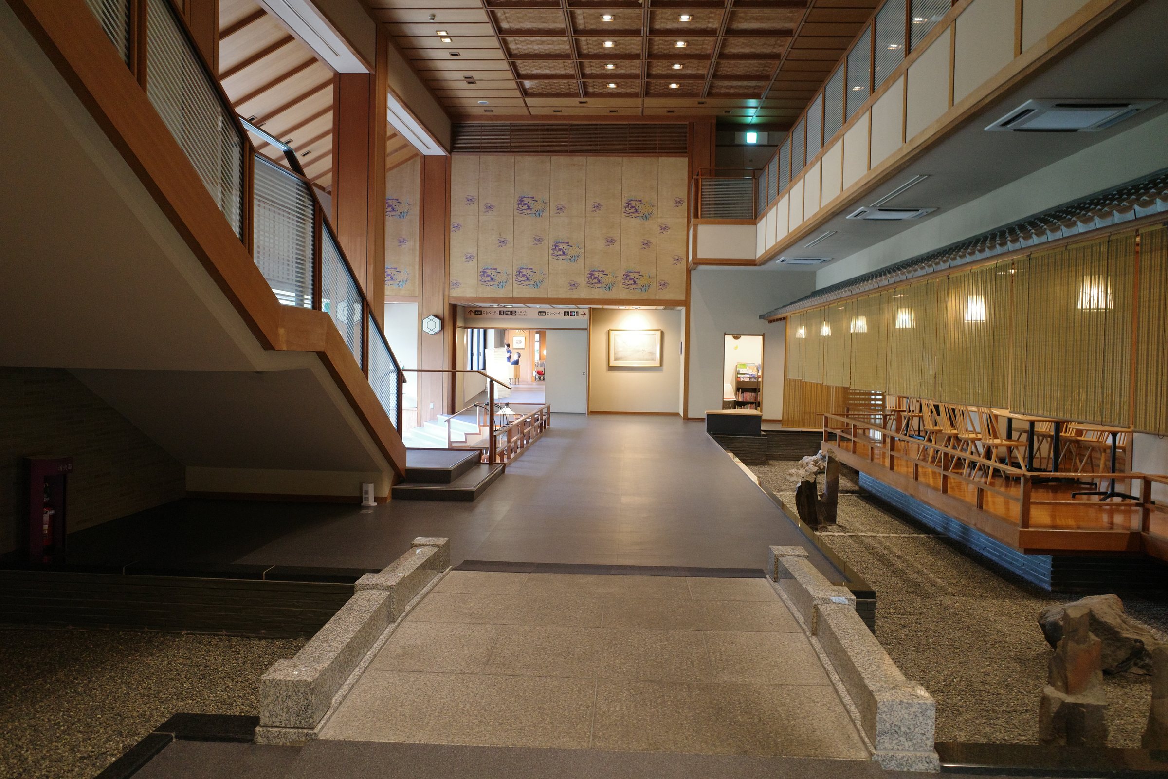The broad interior walkway, with wooden lattice and a stair down to the garden lounge.