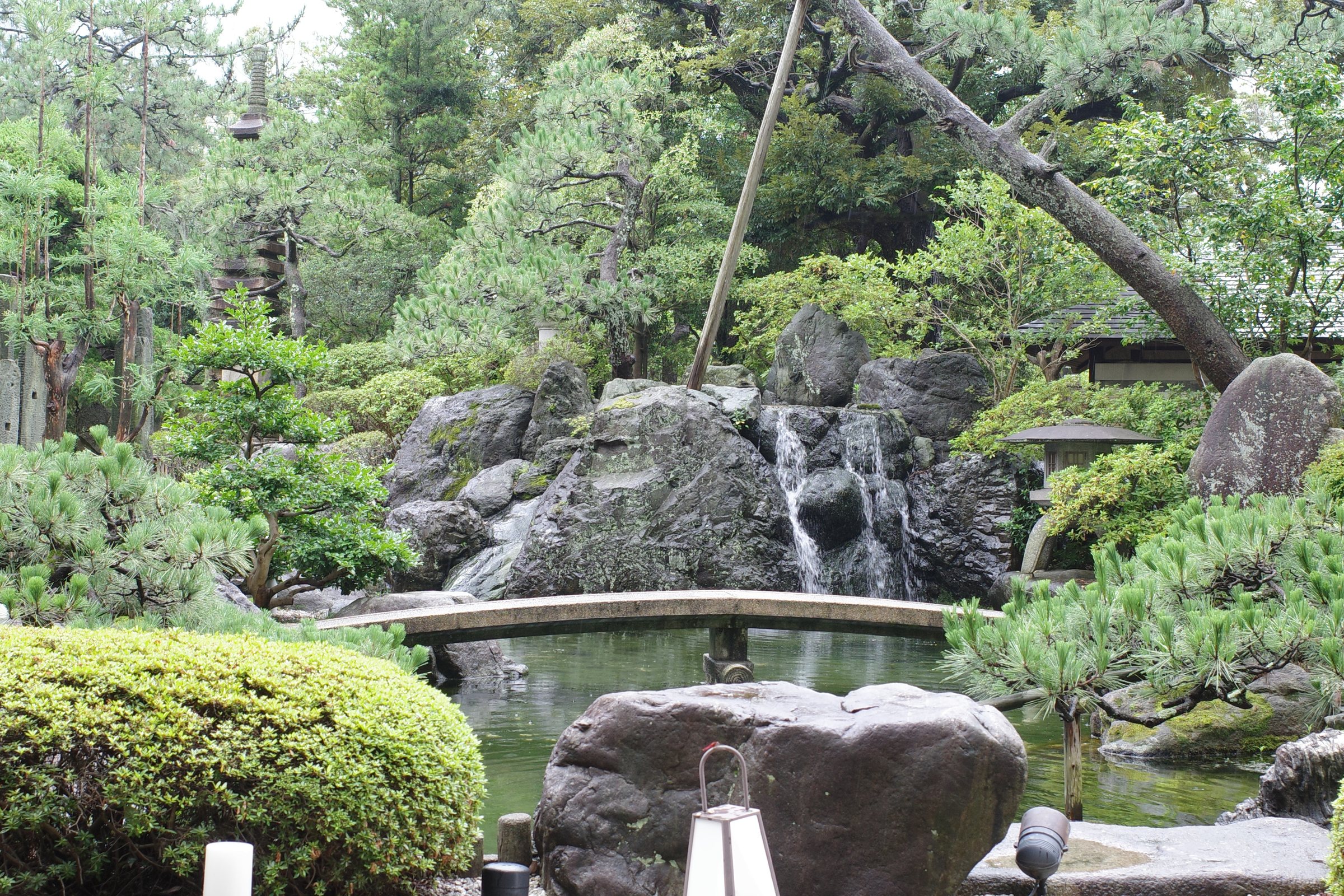 A small waterfall and stone bridge in the garden.