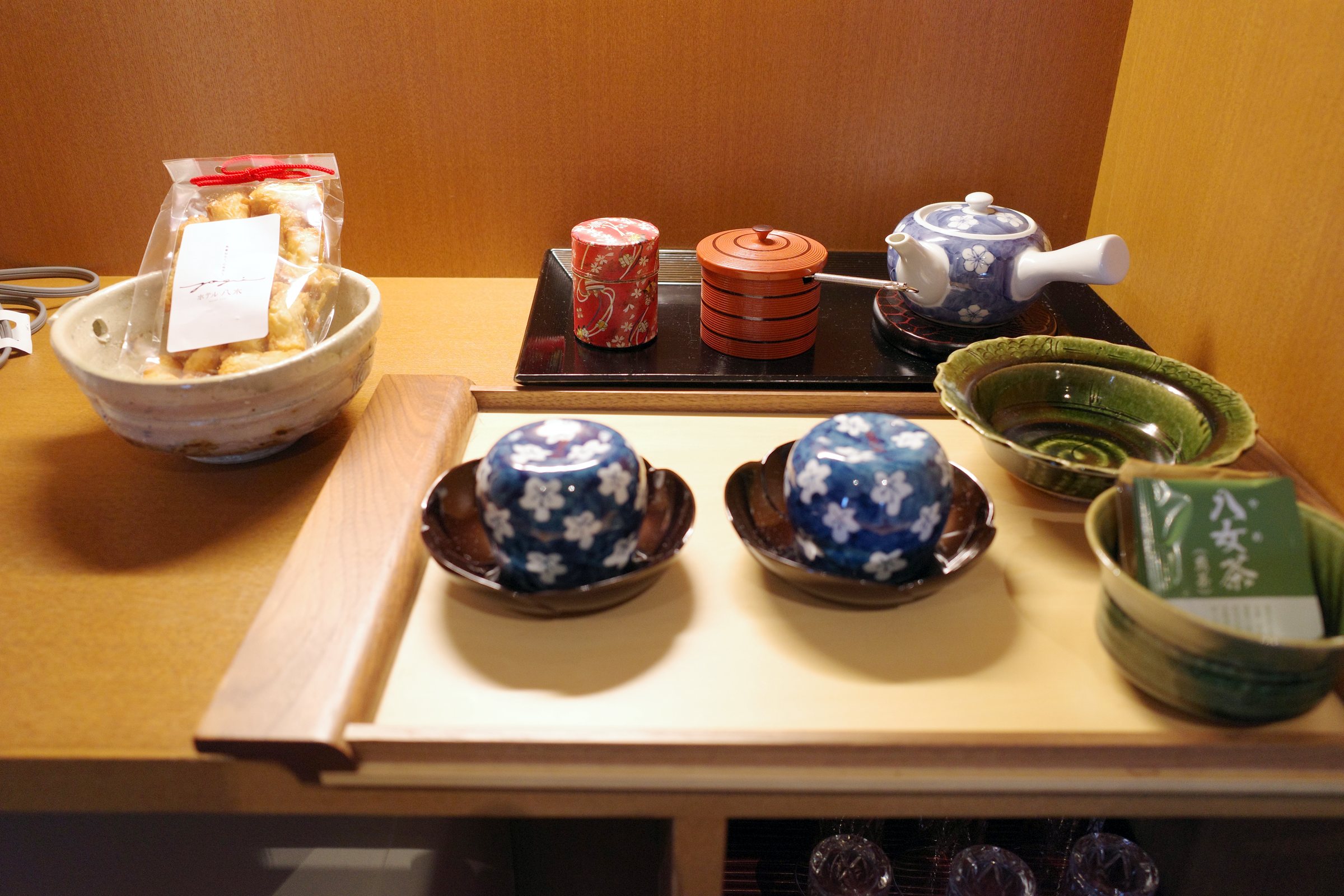 Tea caddies, cups and a bowl of okaki rice crackers.