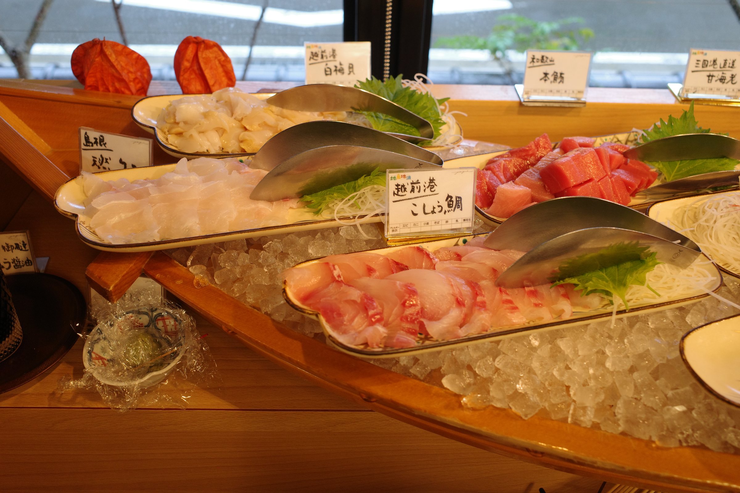The fresh corner: sashimi on a wooden boat over ice.