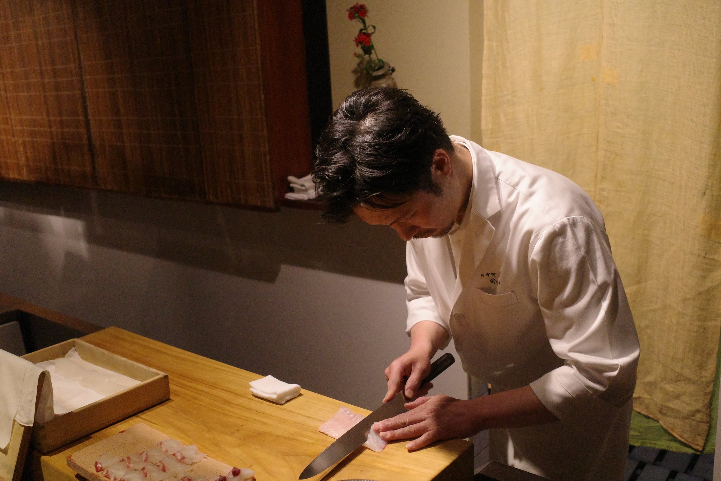 Slicing fish for sashimi at the counter.