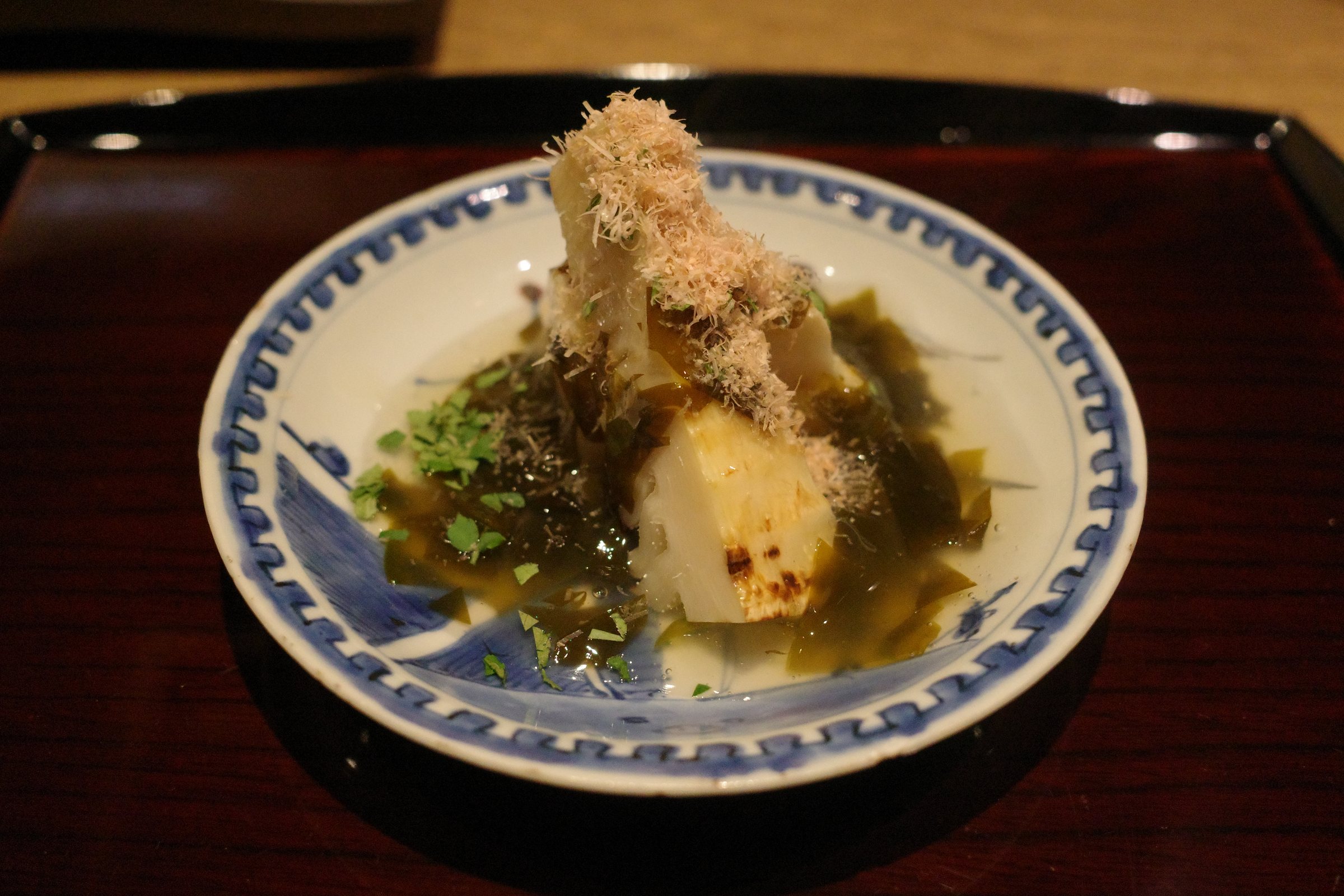 Grilled bamboo shoot with wakame, bonito flakes and kinome leaves.