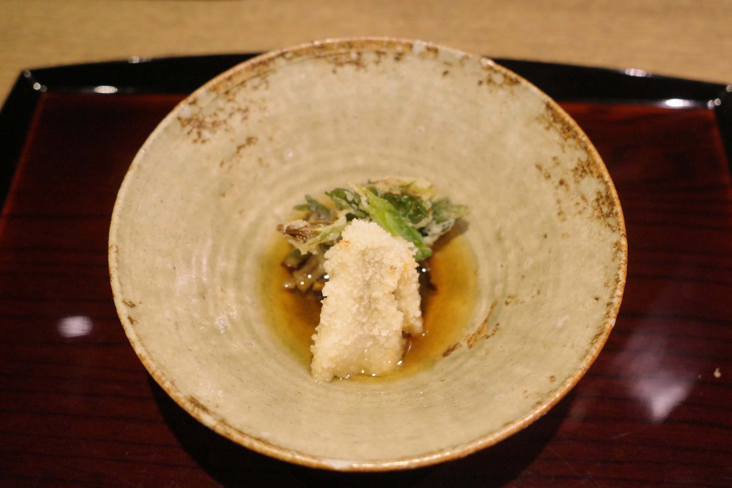 Fried kisu and a fritter of wild garlic in a light broth.