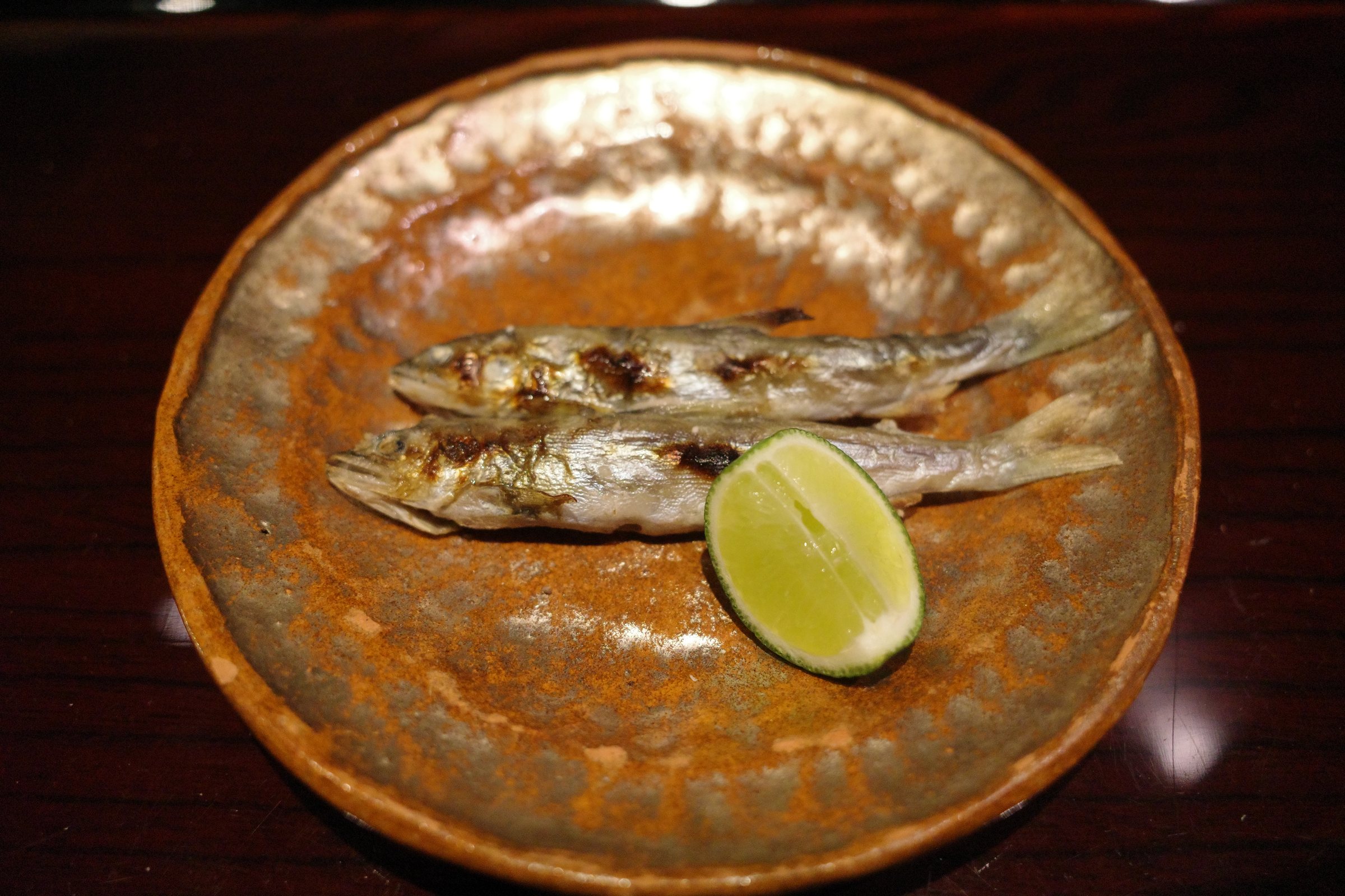 Two small ayu, grilled, with a wedge of sudachi.