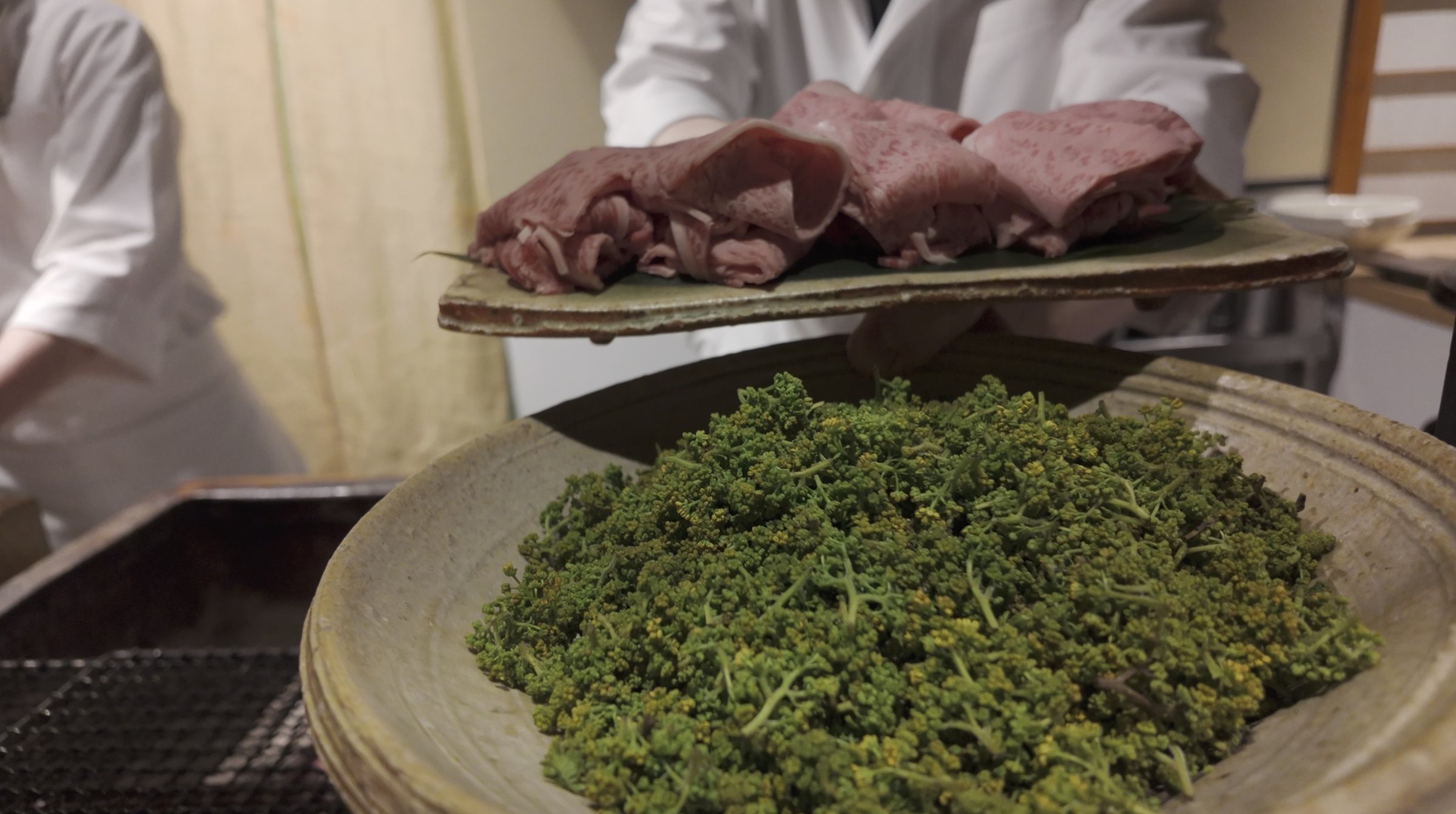 Beef carried to the counter over a bed of flower sansho.
