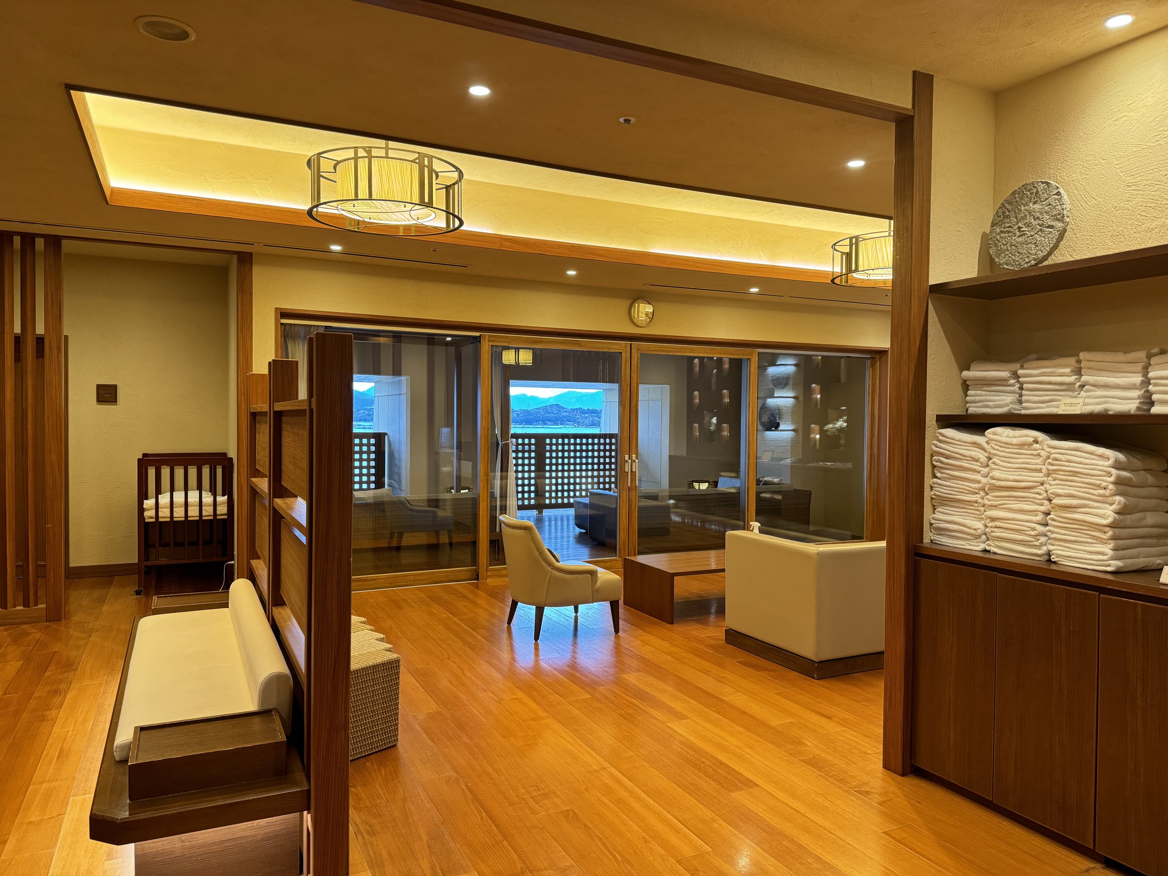 The changing room, with towel shelves, wooden benches and a lounge by the windows.
