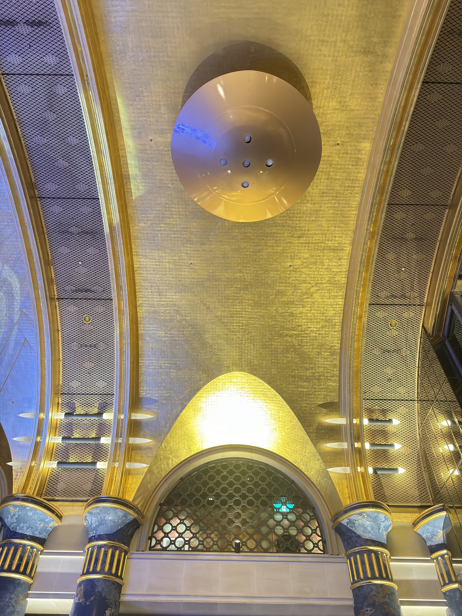 The gilded vault ends in a gold-leaf apse above blue columns.