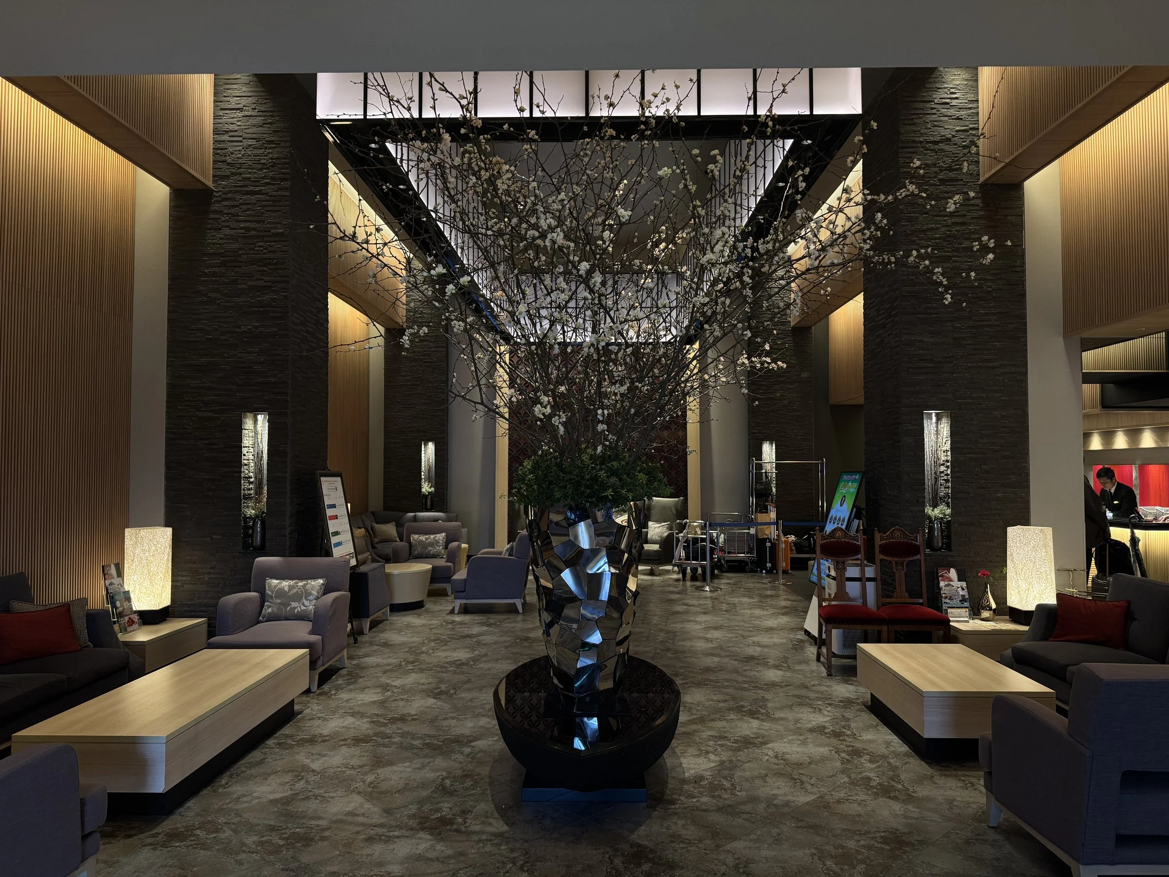 The lobby, under a tall arrangement of blossoming branches.