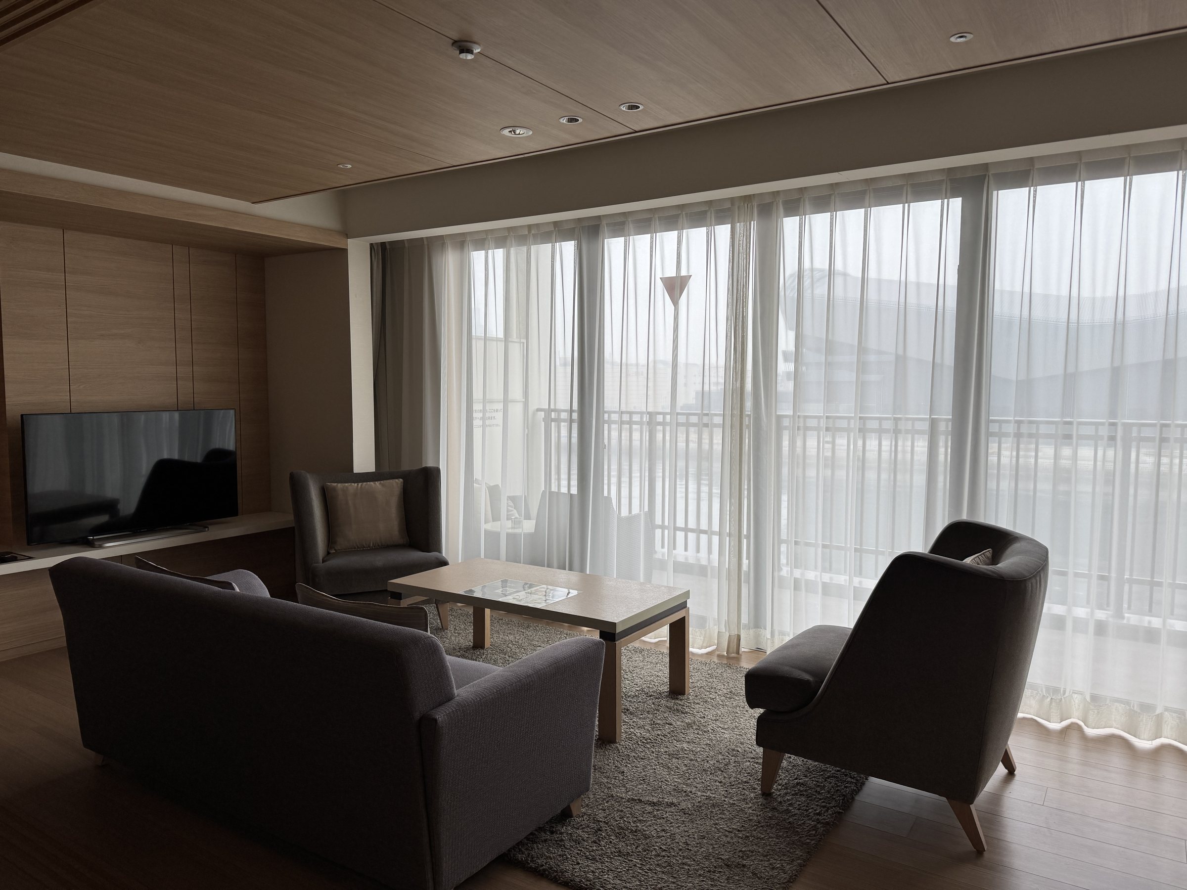 The living room, with sofas and the harbor beyond the glass.