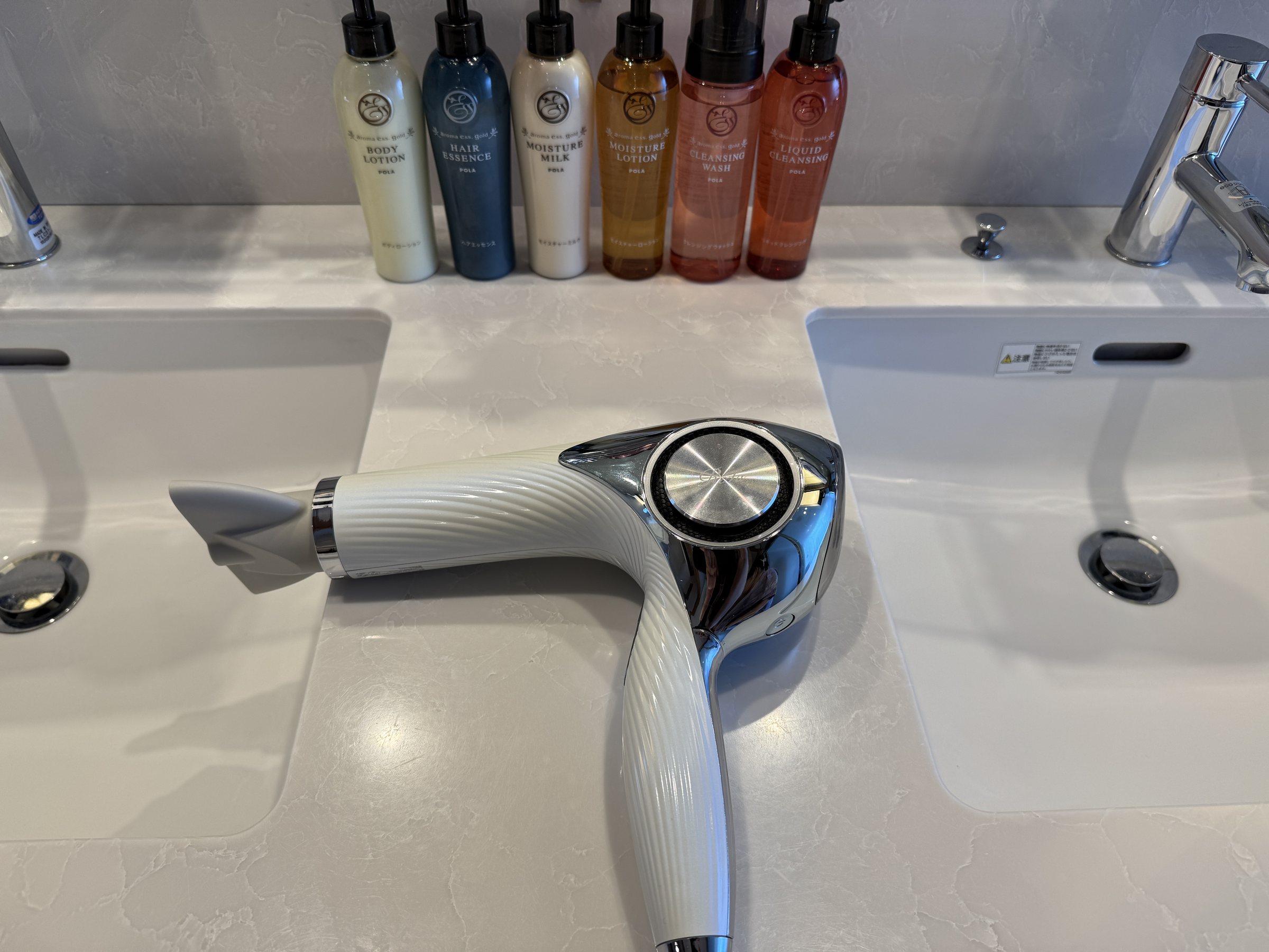 Bottled toiletries and a hairdryer at the washbasin.