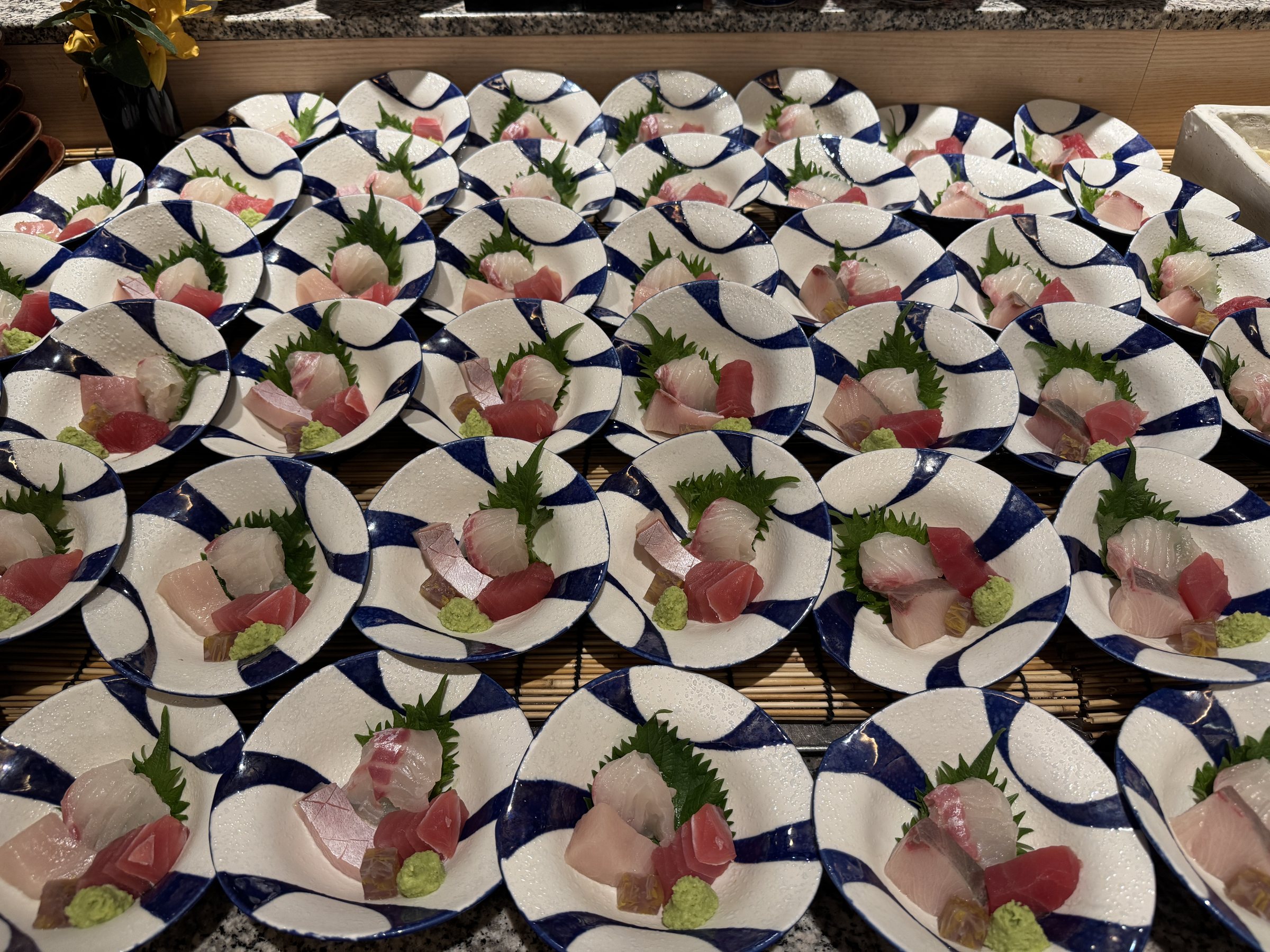 Rows of sashimi plates, ready to take.