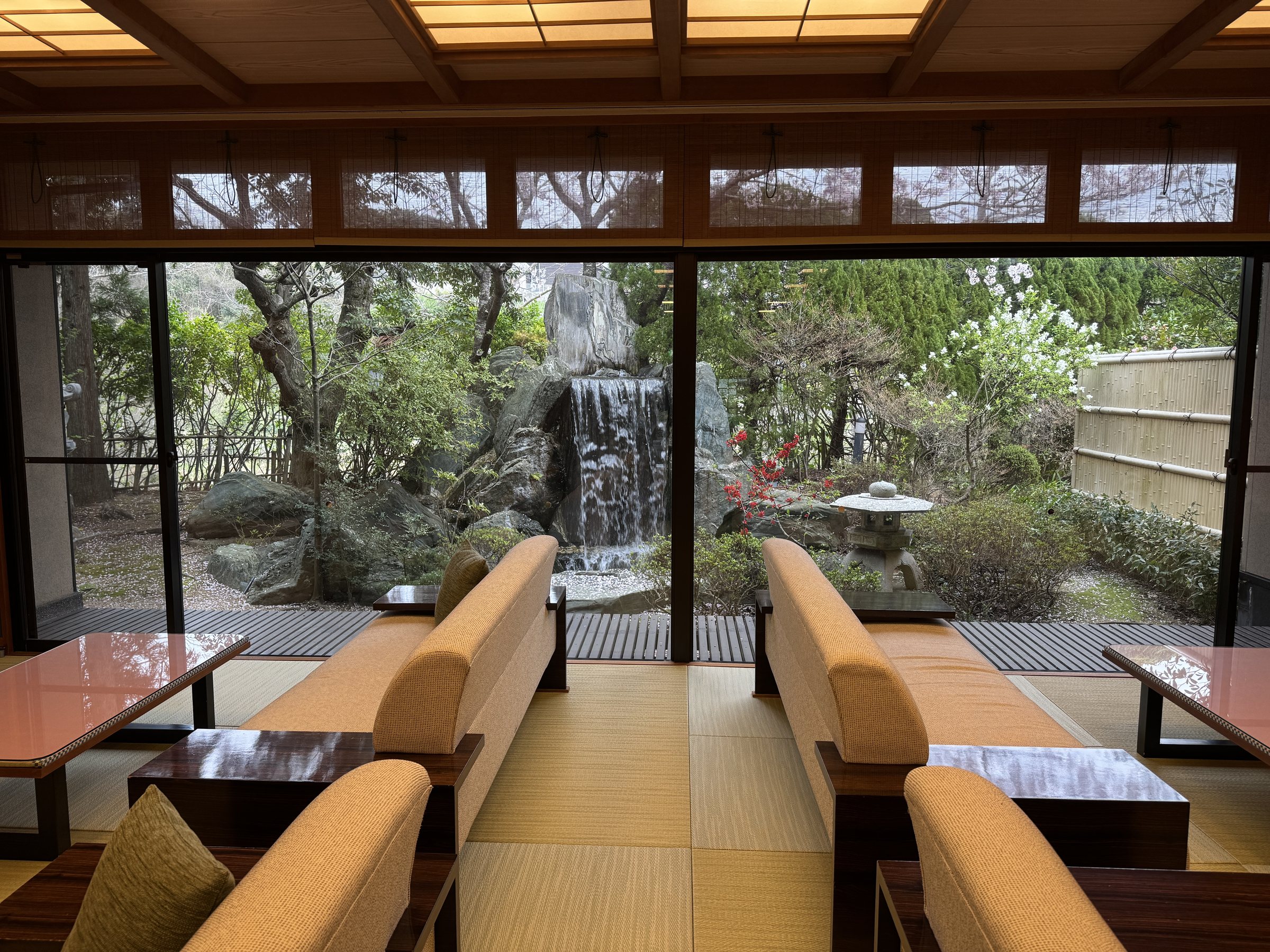 The lounge: tatami, deep sofas and a garden waterfall beyond the glass.