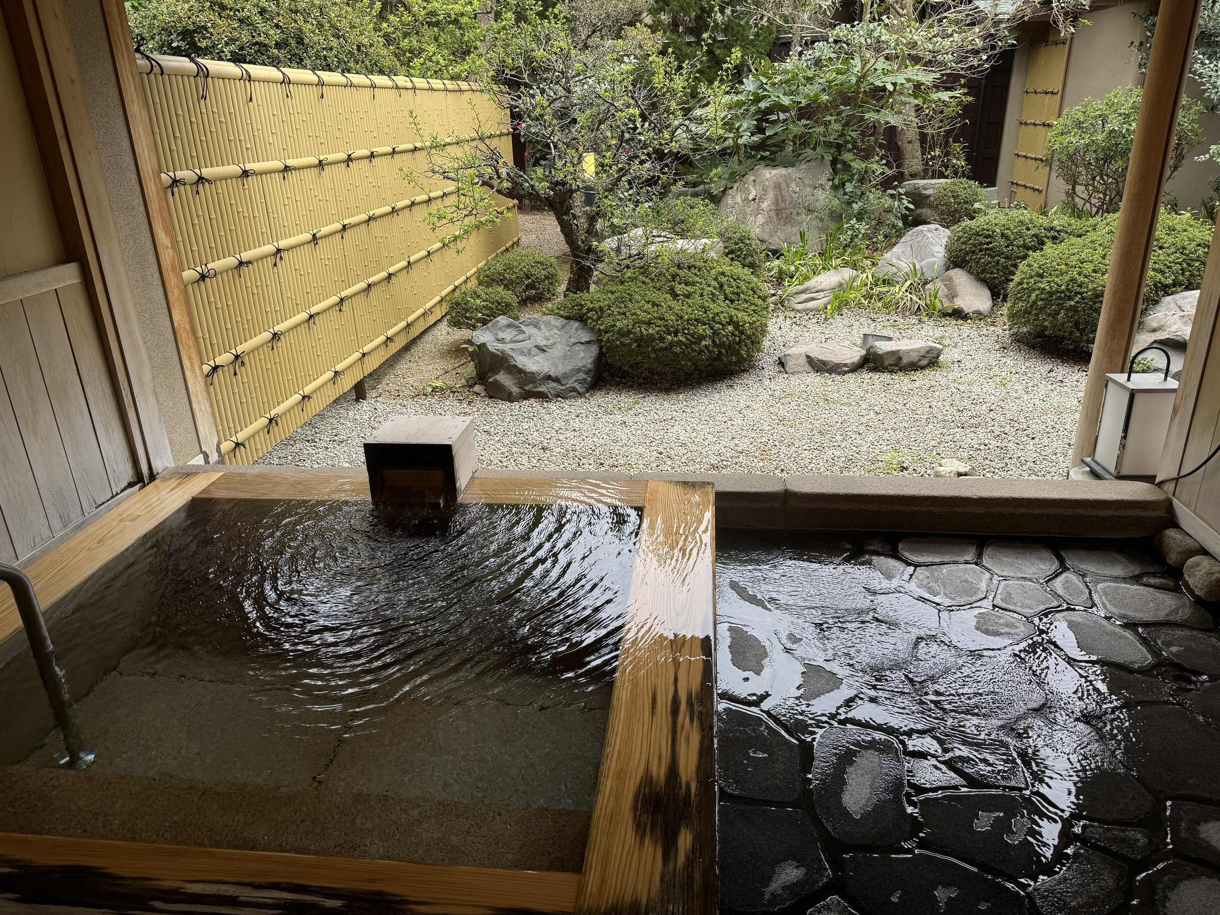 Water spilling over the stone-paved floor at the bath’s edge.
