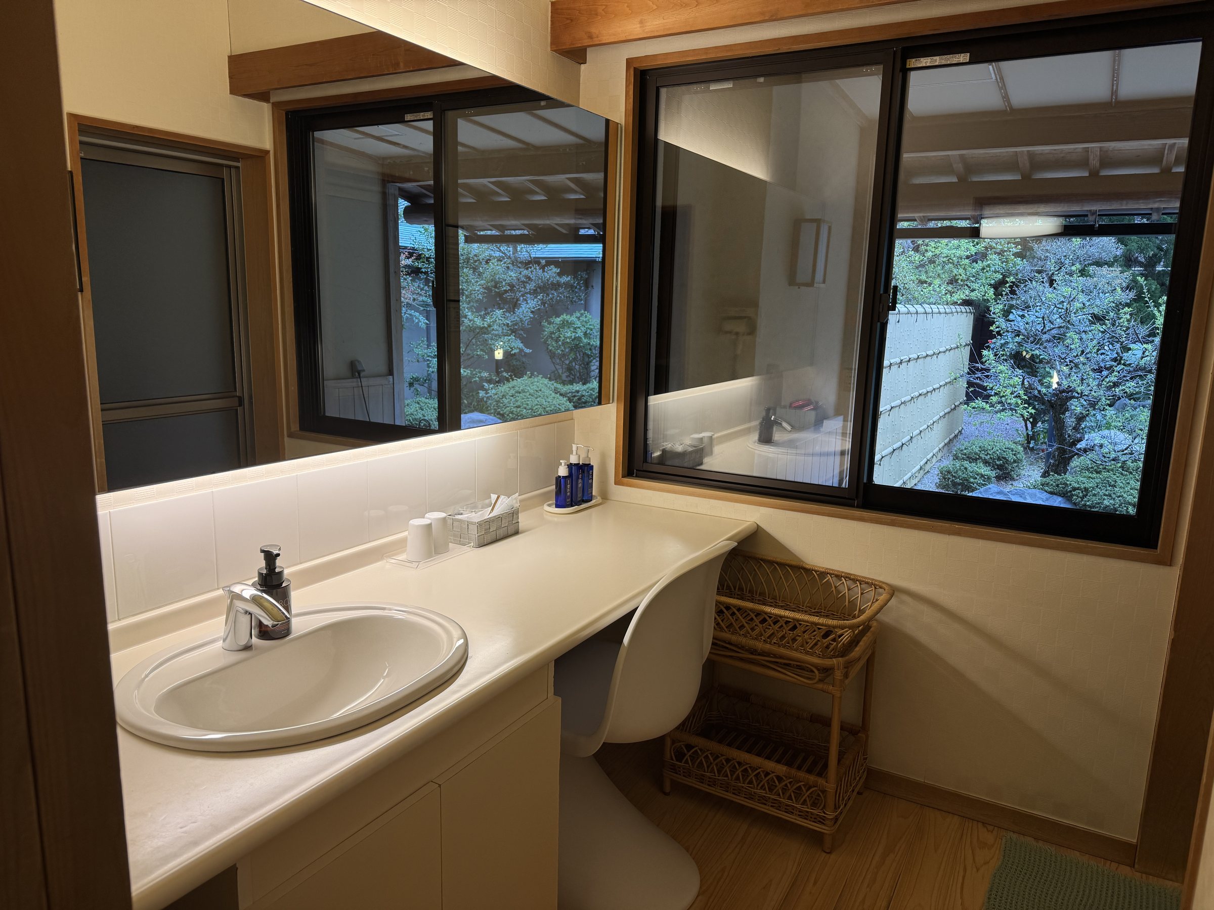 The washroom: a long white counter, a mirror and a window onto the garden.