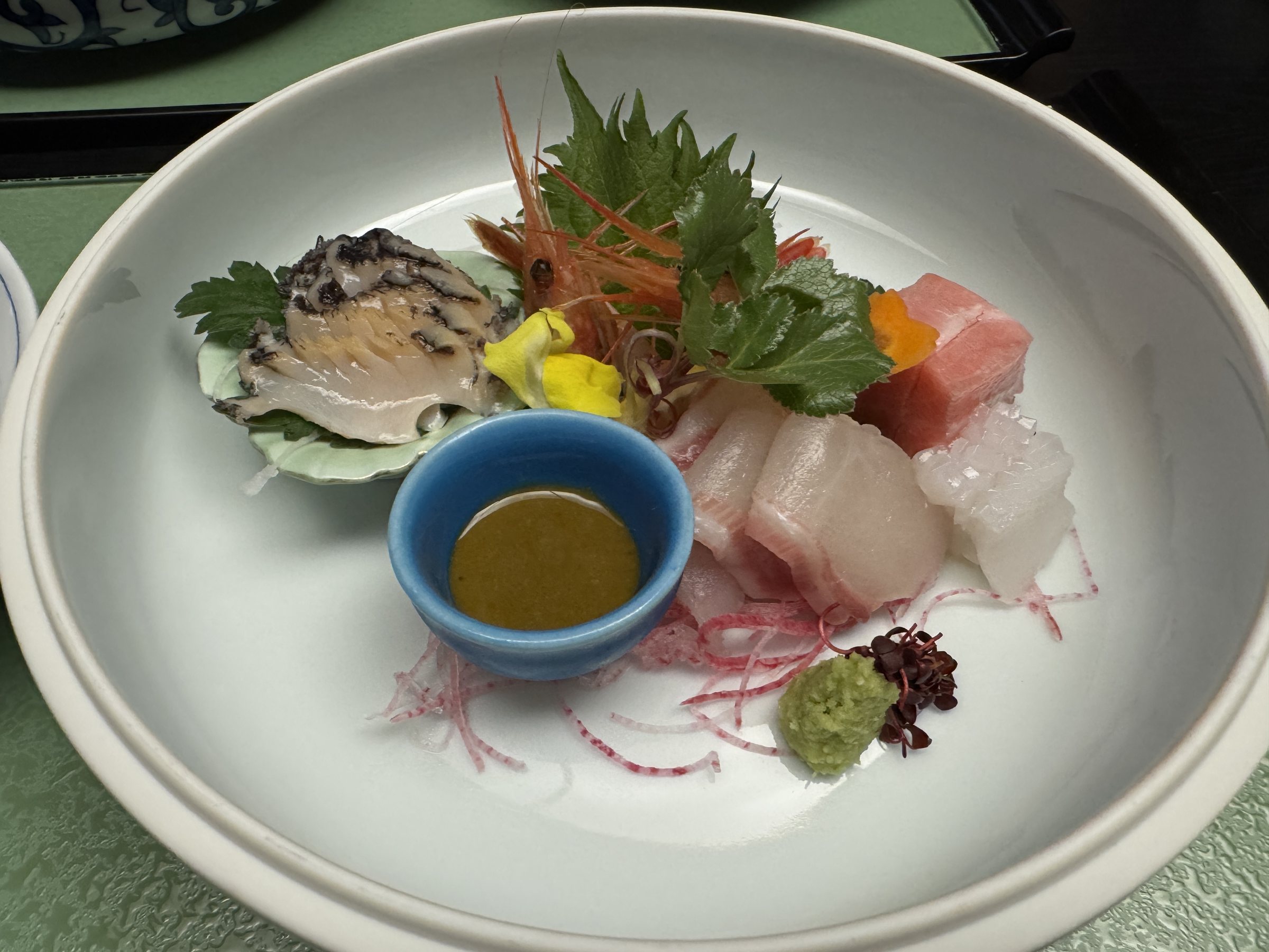 The sashimi, with abalone in its shell at the back.