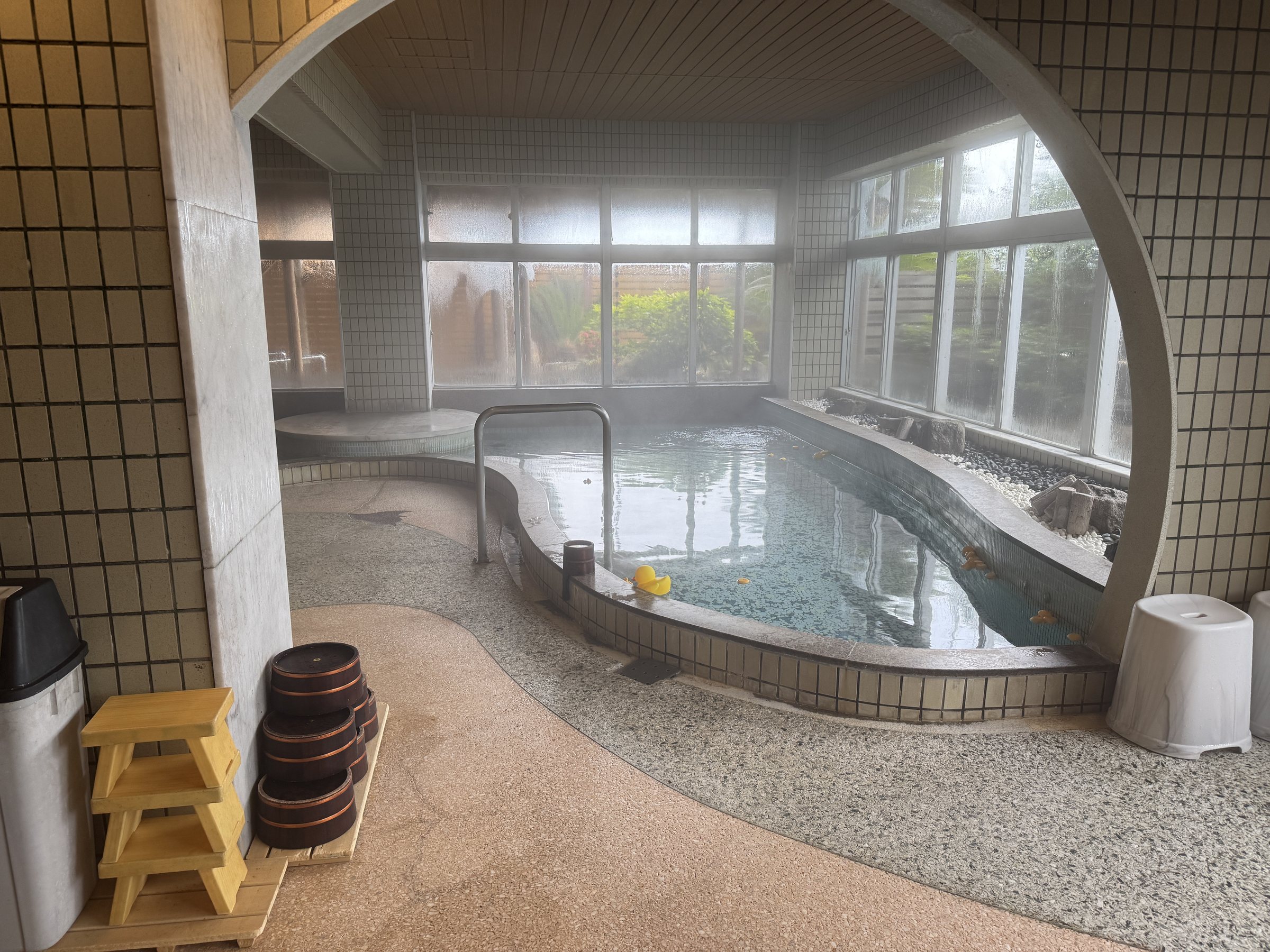 Another bath, beneath a large round window.