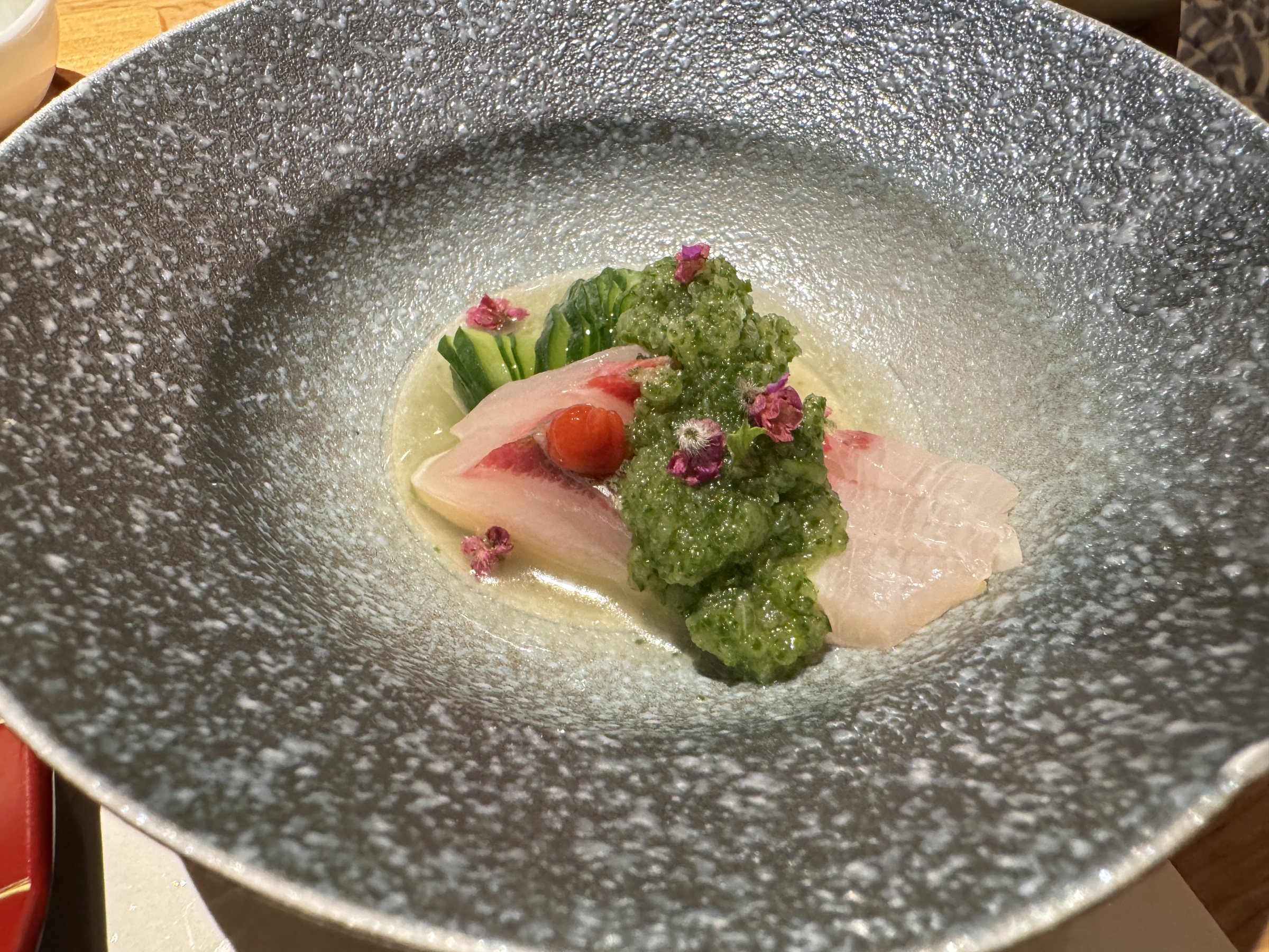 A raw fish dish in a gray bowl.
