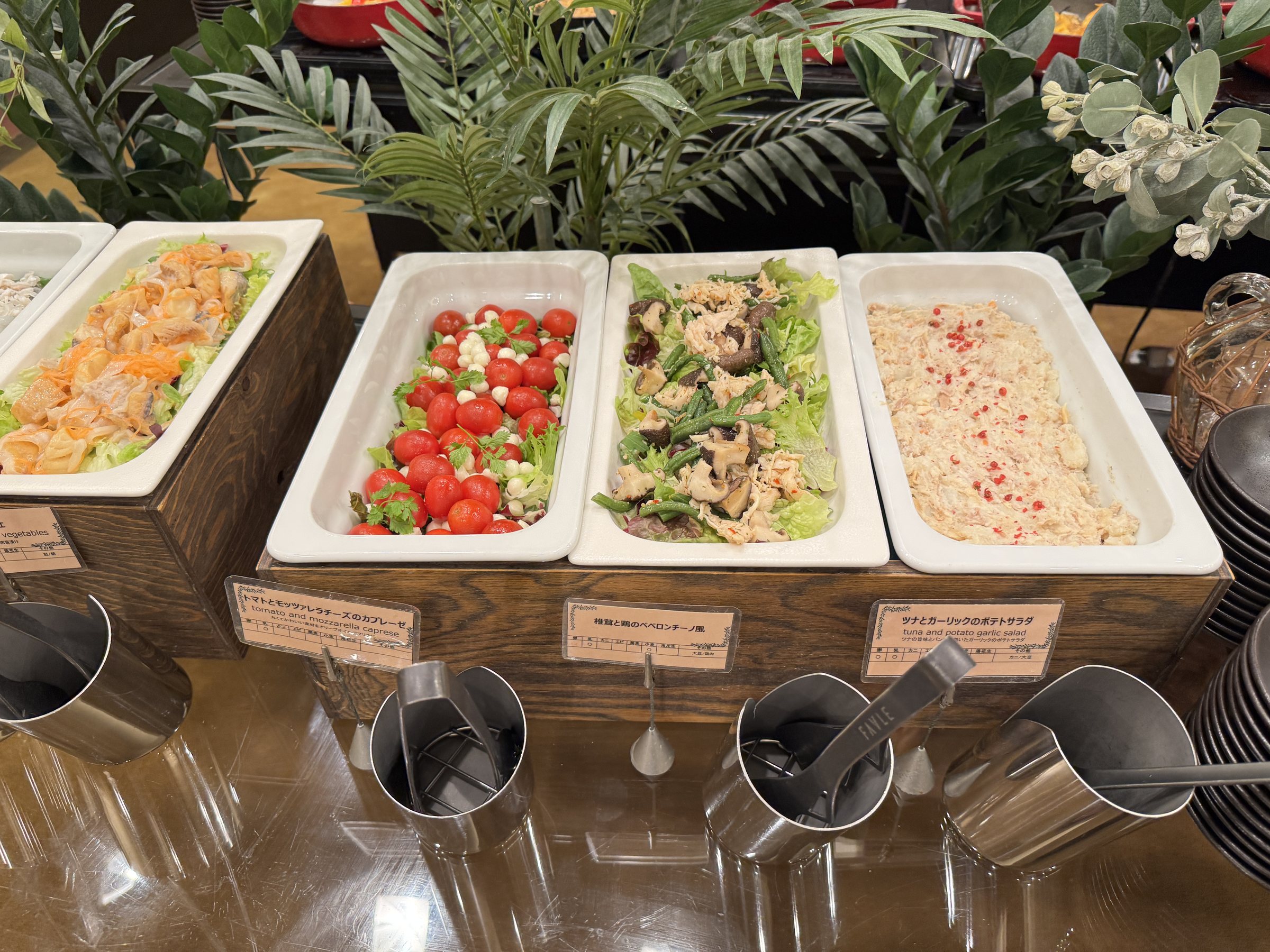 Seafood and vegetable dishes in white trays.