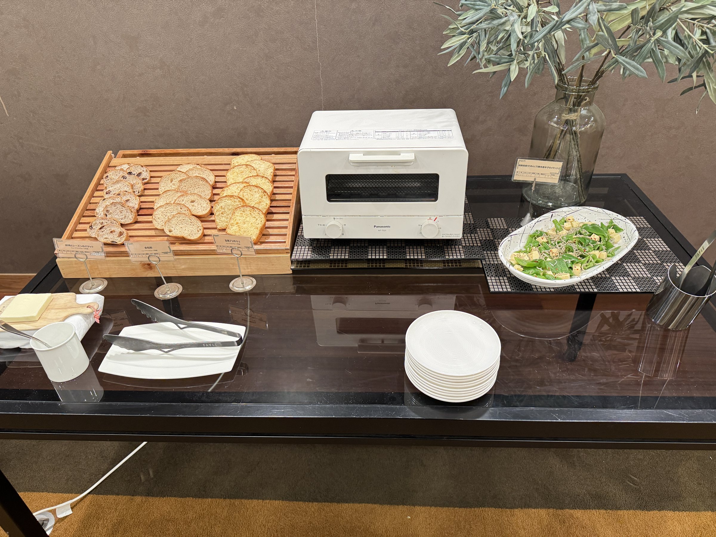 Sliced bread on a wooden board beside a toaster.