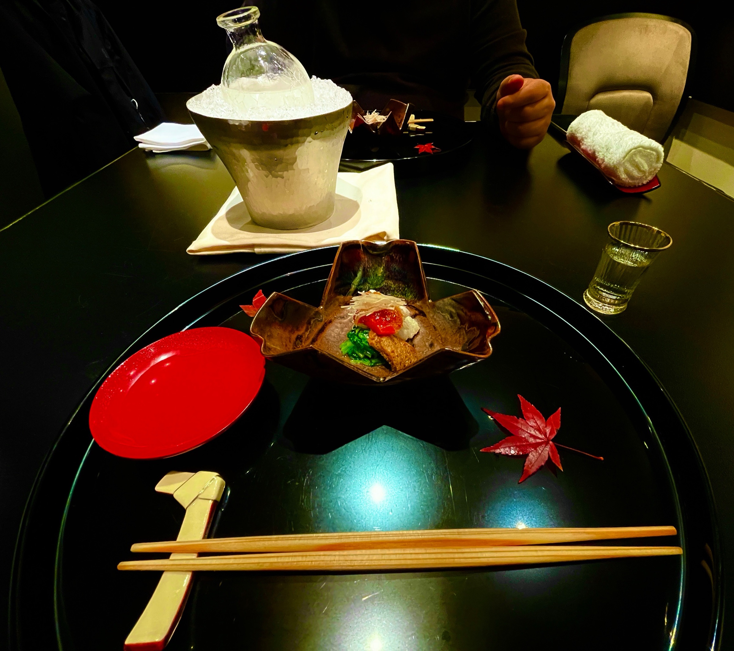An autumn table: black lacquer, vermilion and a maple leaf.