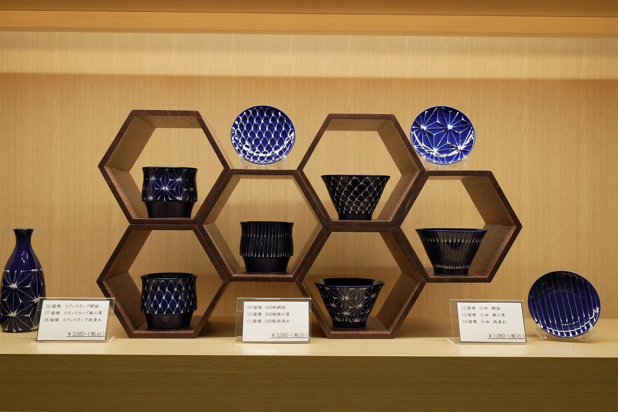 Indigo-and-white ceramics displayed in a honeycomb of timber.