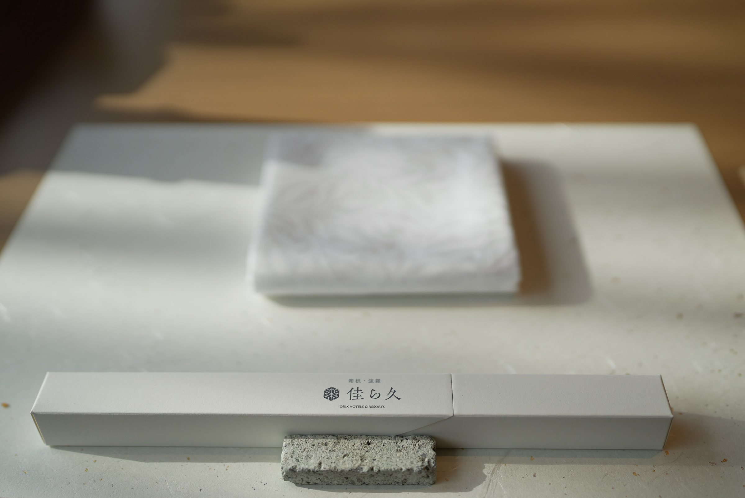 The house chopsticks, boxed, on an ivory table.