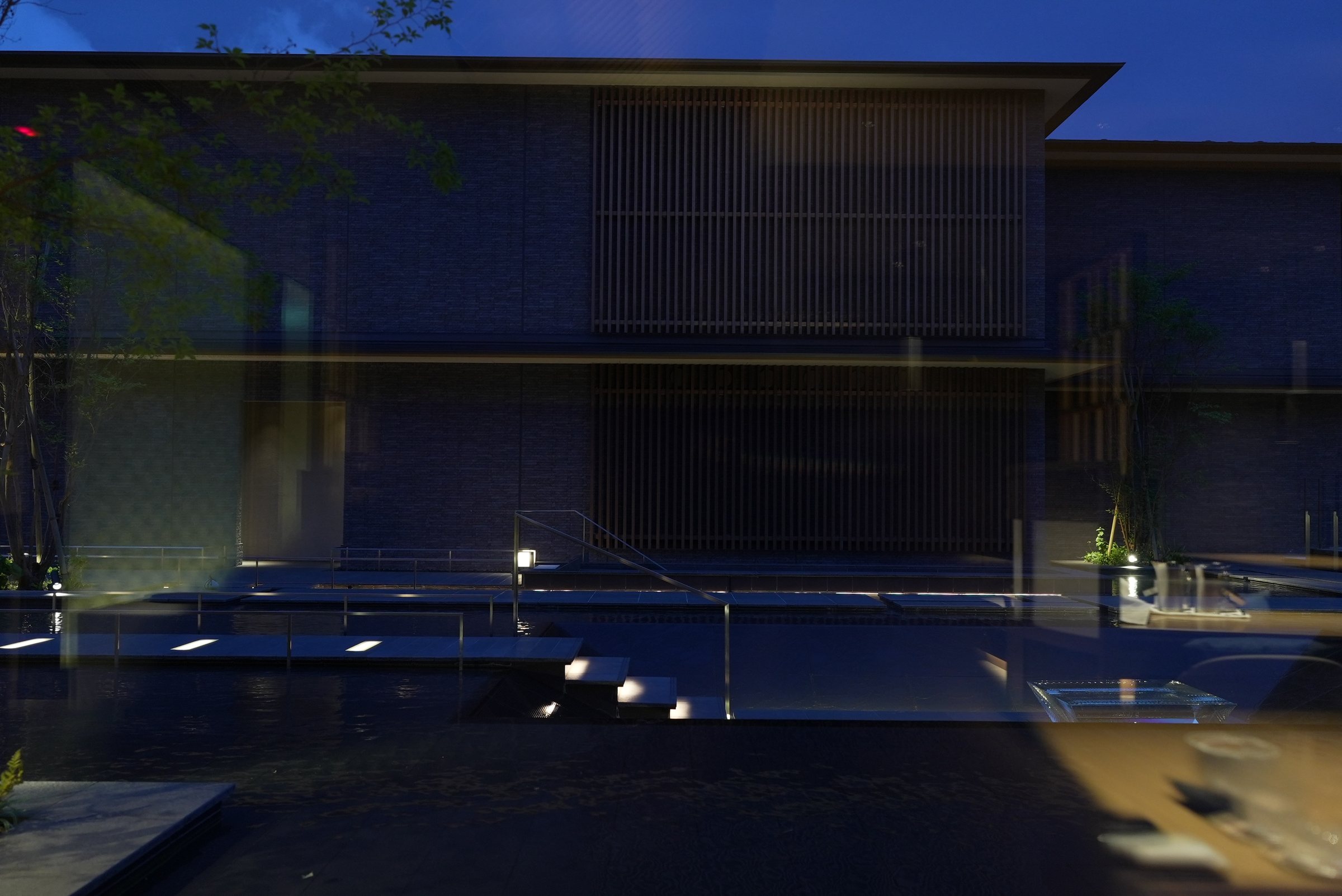 The water garden at dusk, the building lit behind it.