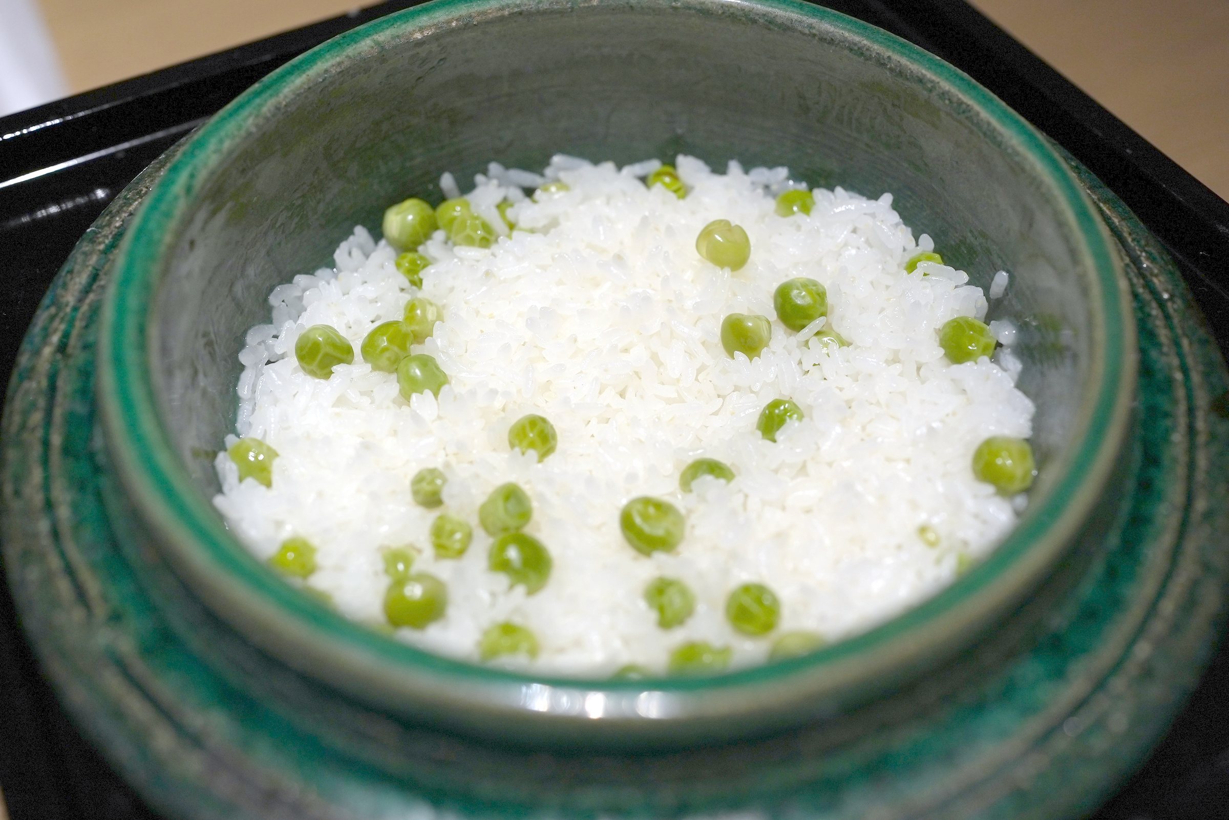 Pea rice in its pot, the peas bright against the white grains.