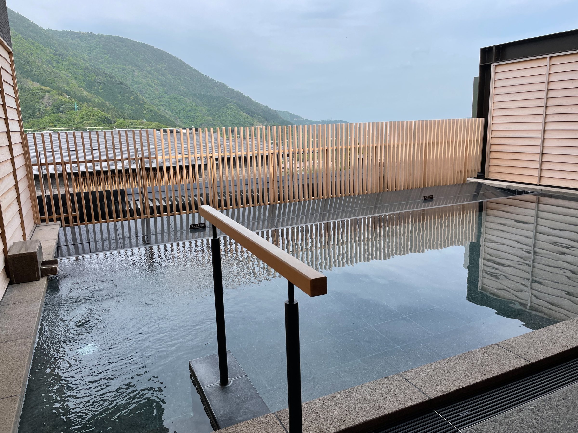 The open-air bath, its surface level with the hills.