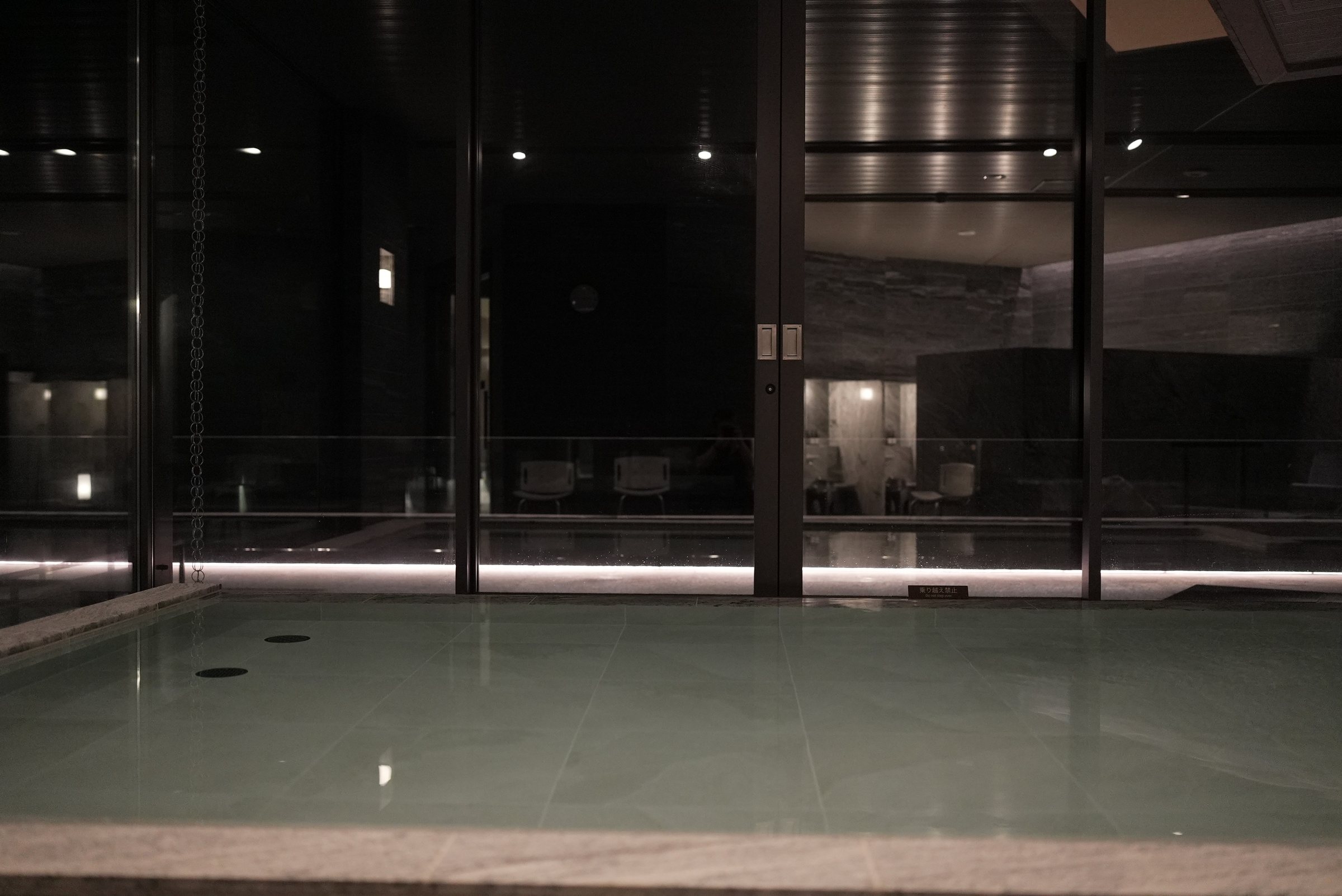 After dark: the stone bath lit low and still.