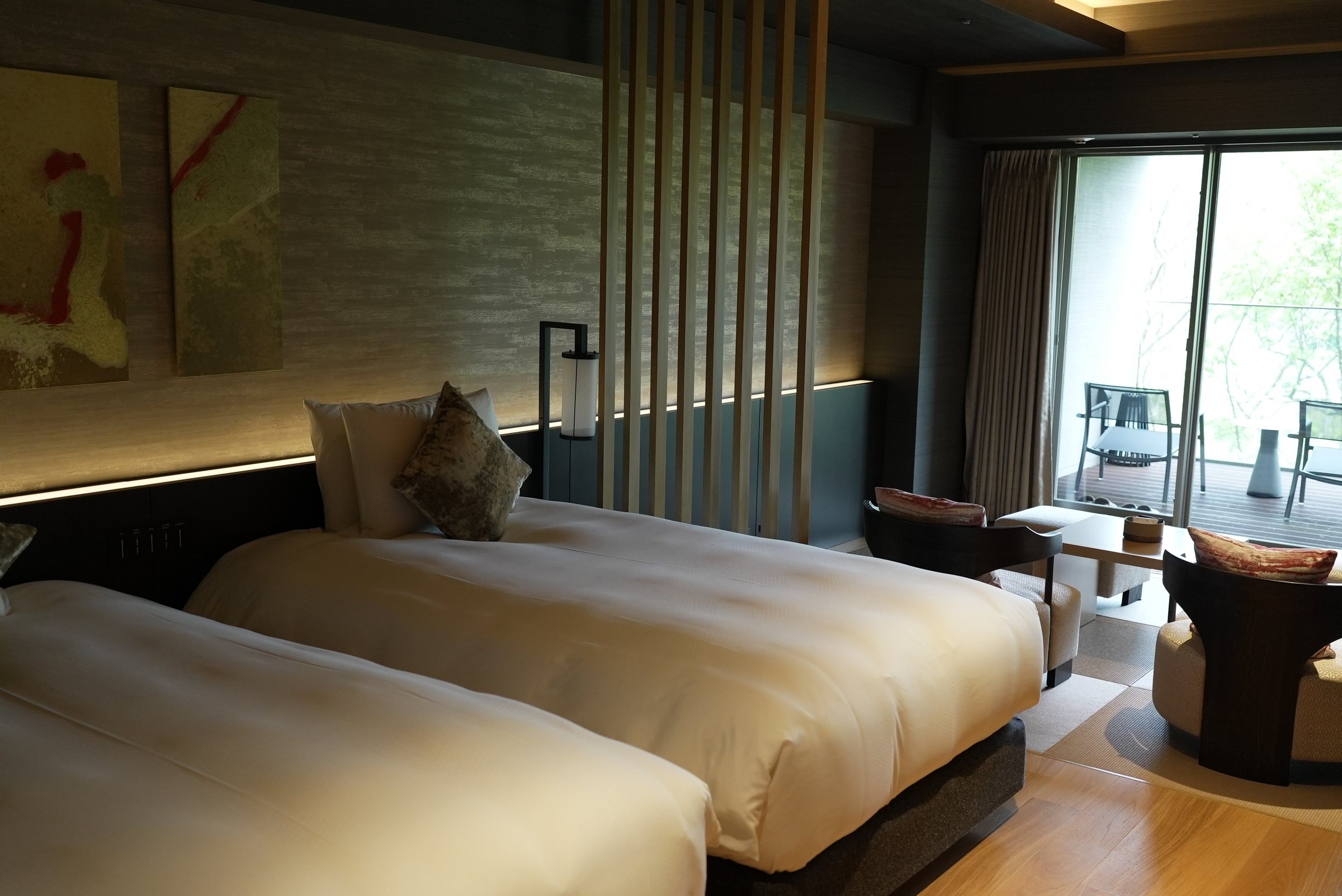 Twin beds, low lighting and a view of green.