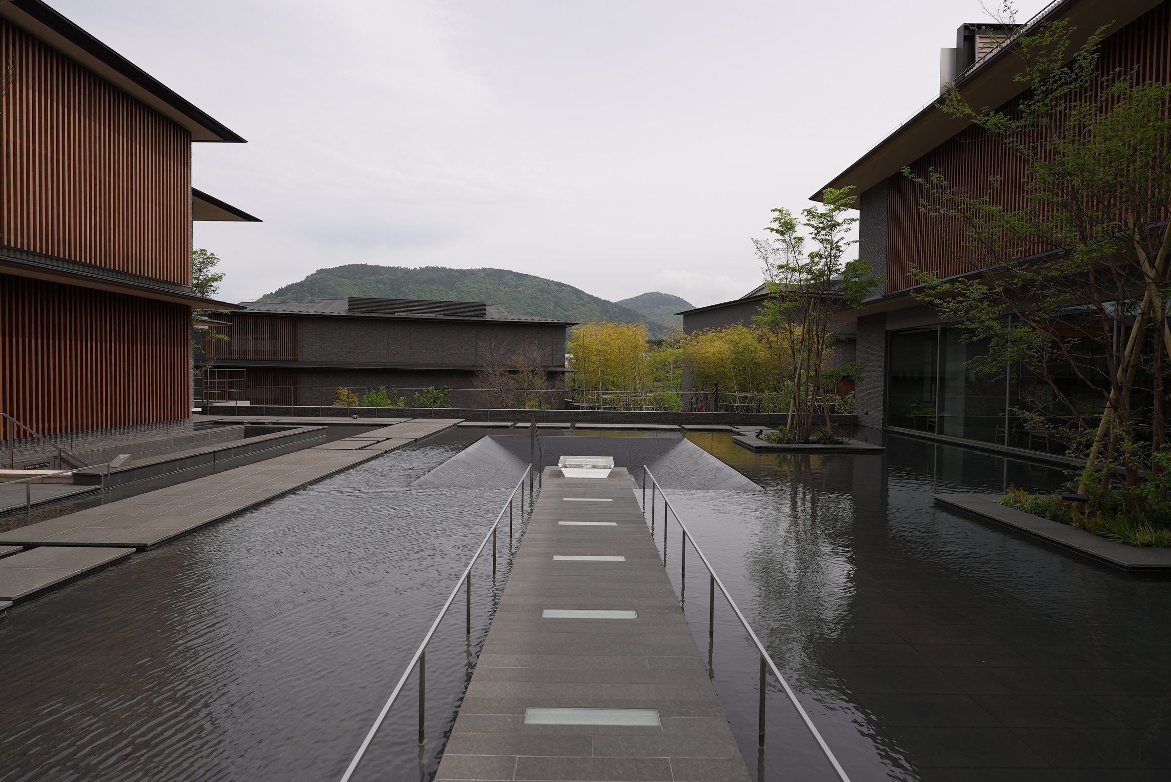 A walkway runs between twin reflecting pools toward the hills.