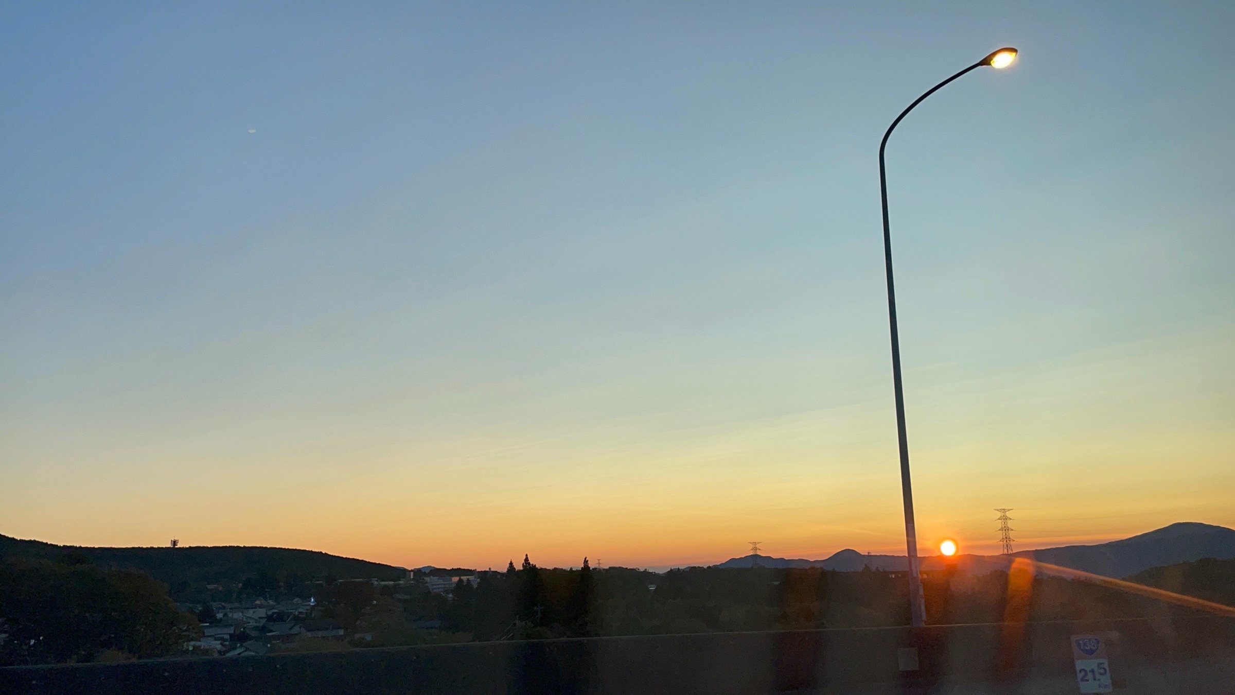 Sunrise over the Fuji foothills, a lone streetlamp still lit.