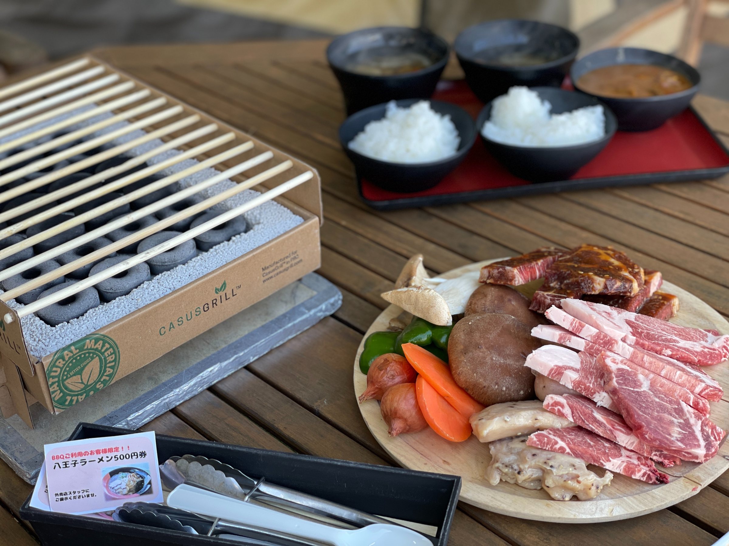The set-up: a compact charcoal grill, bowls of rice and curry, and the meat platter.
